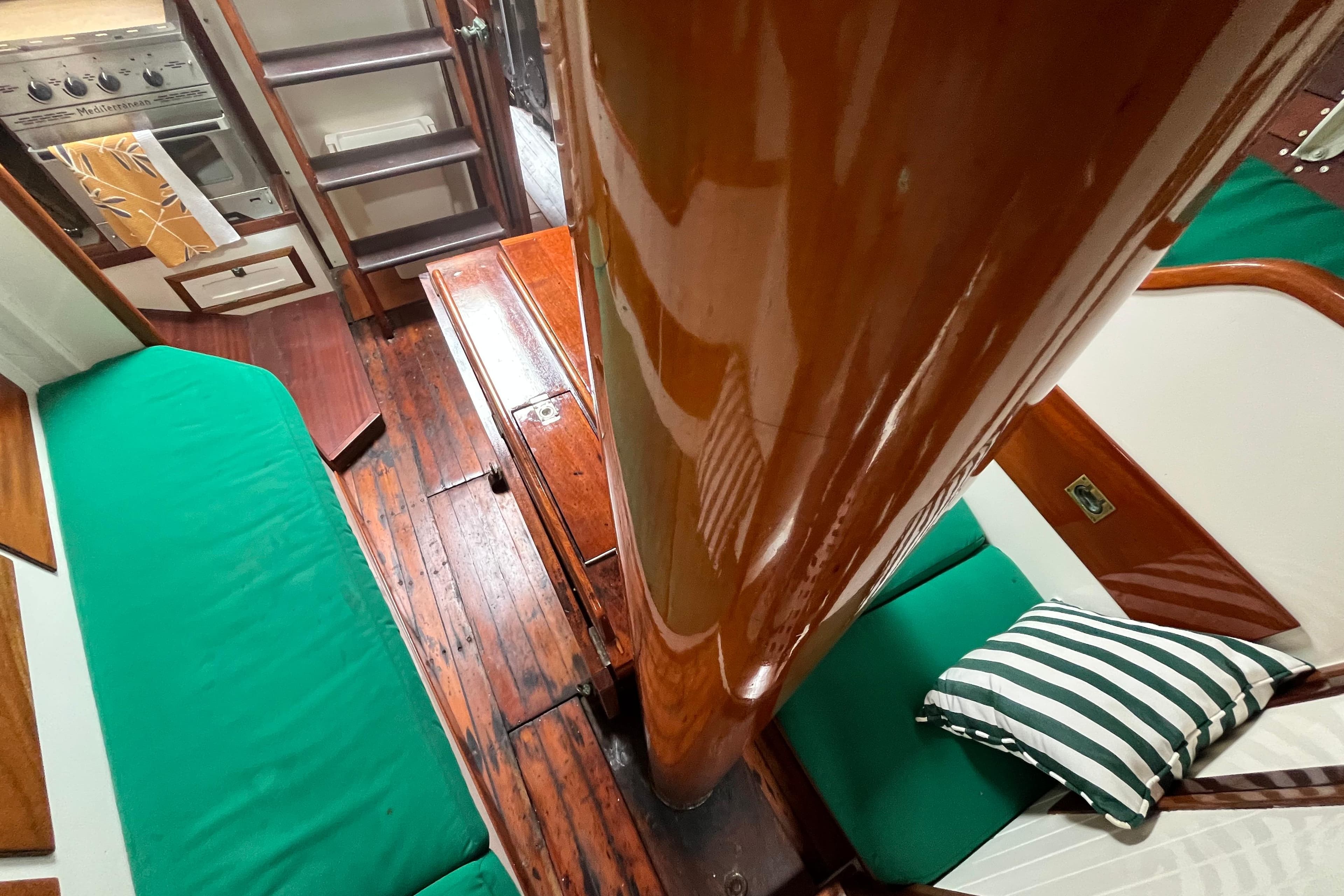 Interior of 1947 Murray Peterson Schooner with wooden floors and green seating.