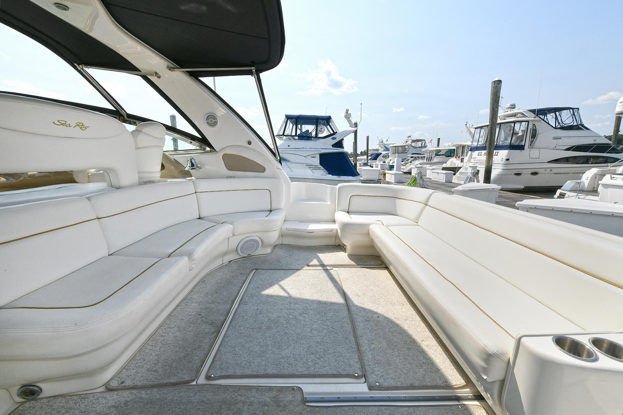 Spacious seating area on a 2000 Sea Ray 460 Sundancer yacht, docked at a marina.