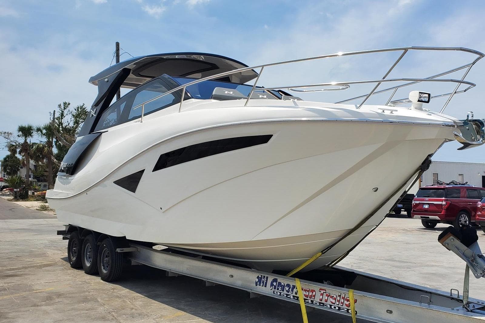 2023 NX Boats NX360 on trailer, sleek design, parked outdoors.