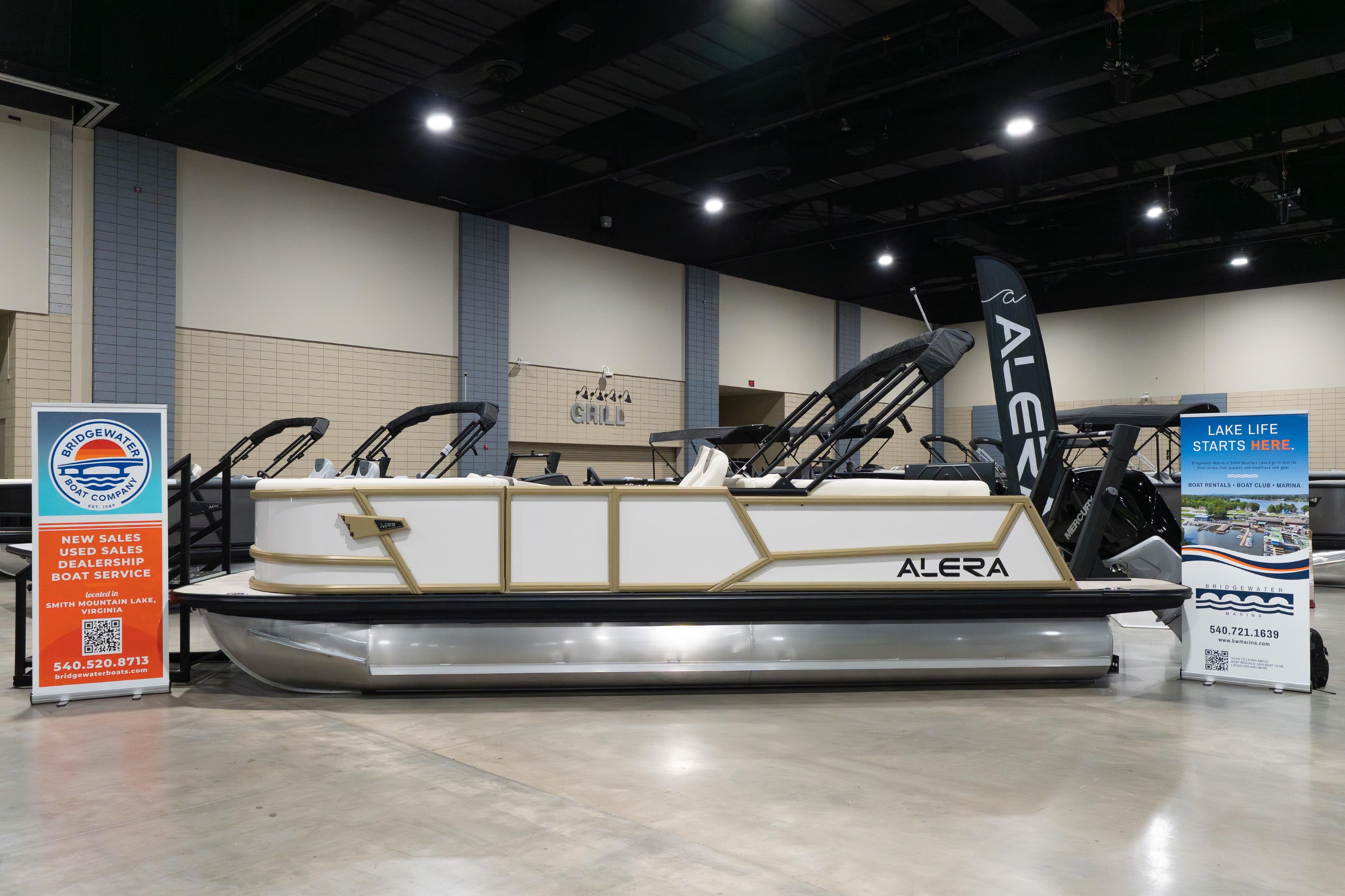 2026 Alera M23Q boat displayed indoors with promotional banners.