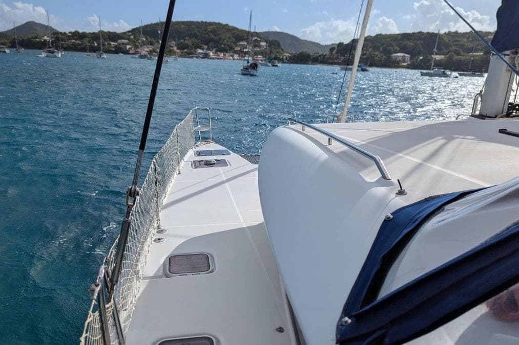 2008 Lagoon 420 sailboat cruising in a scenic bay with distant hills.