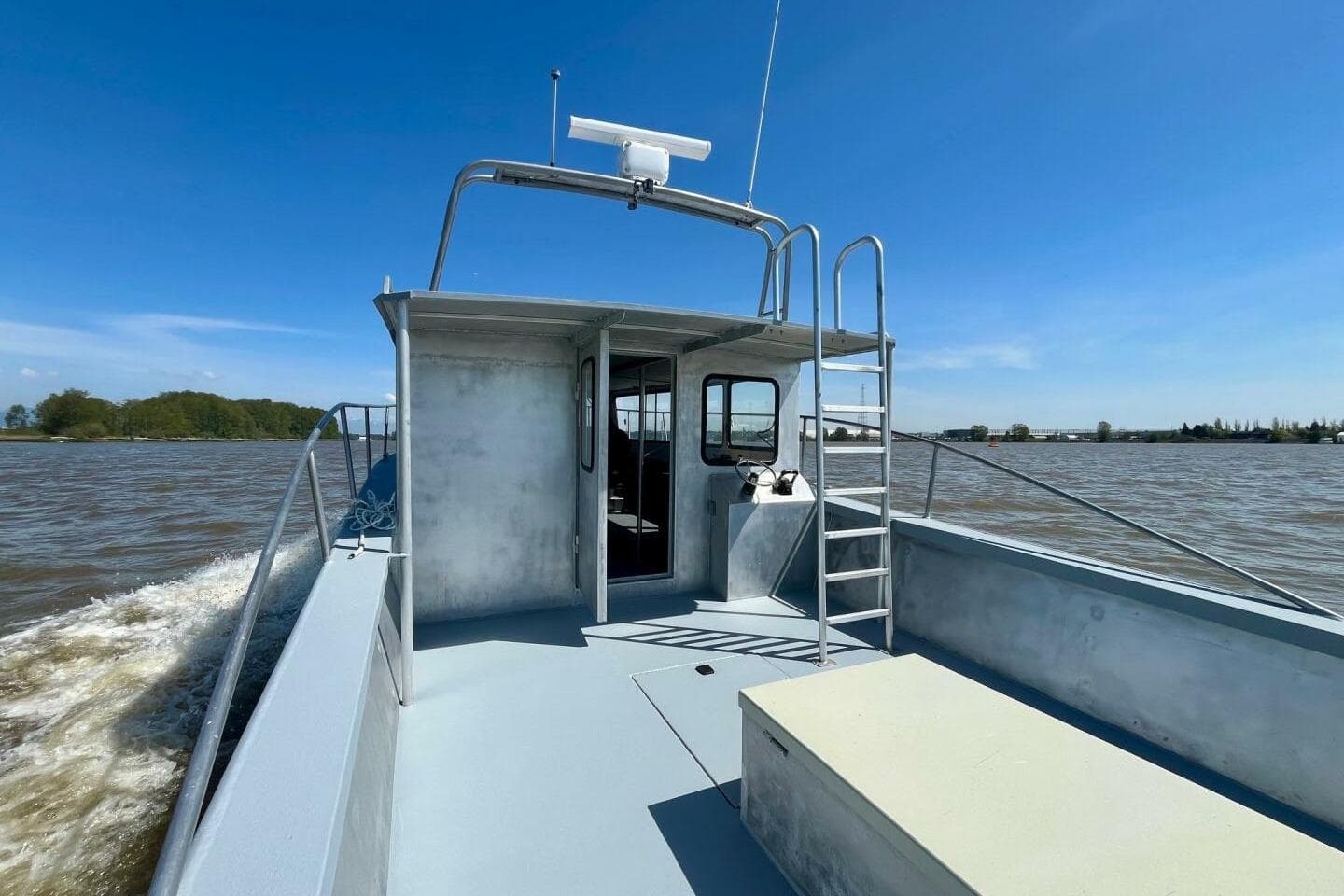 Custom 1990 rebuilt dive boat offshore, cruising on a sunny day with clear skies.