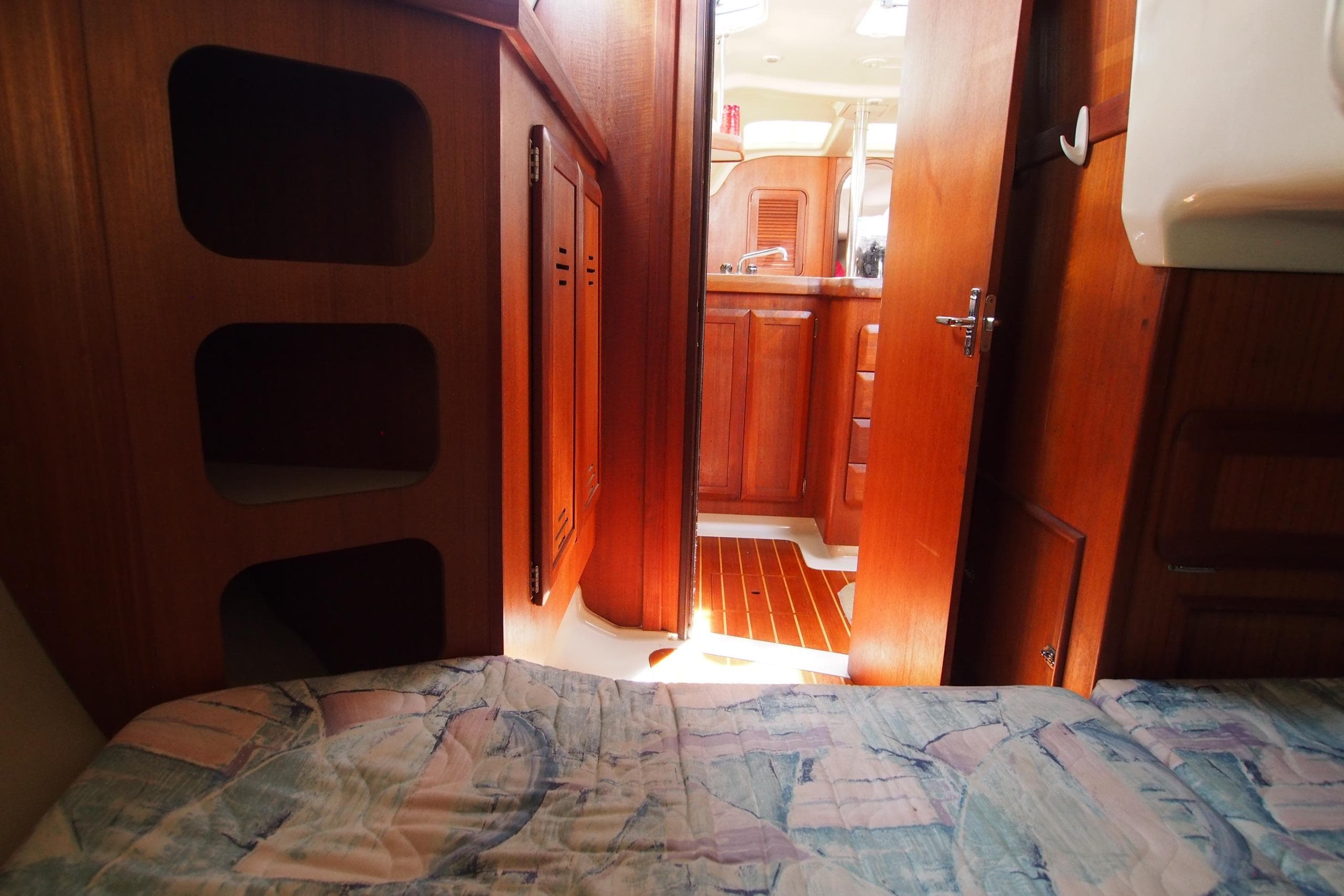 Interior of a 1995 Hunter 336 sailboat, featuring wooden cabinetry and cozy sleeping area.
