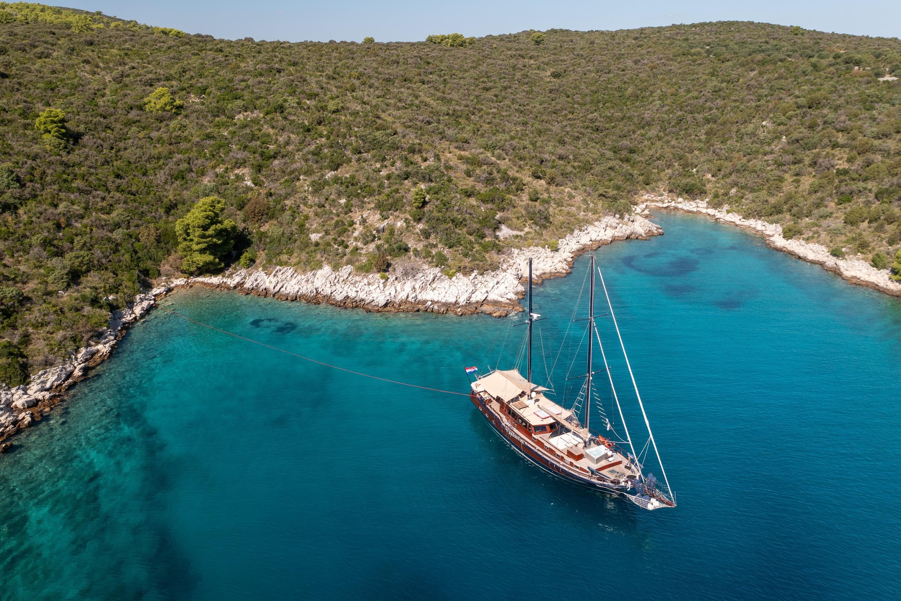 Aerial view of a 2000 Custom GULET yacht anchored in a serene turquoise bay.