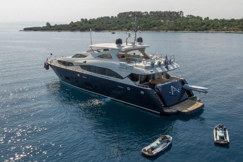 Luxurious 2009 Sunseeker 34 Metre Yacht anchored with jet skis nearby.