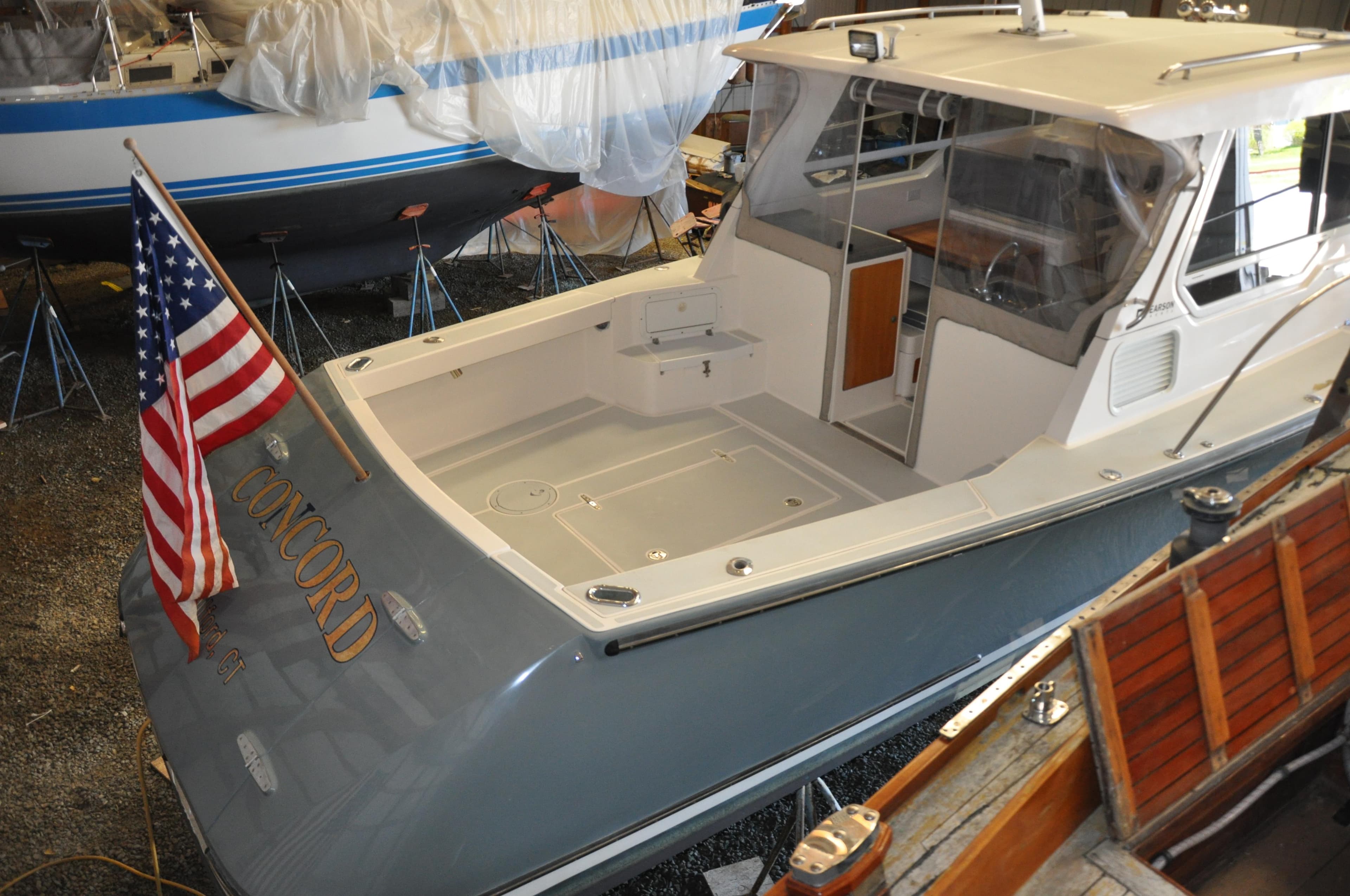 2005 True North 33 boat in storage, featuring spacious deck and American flag.