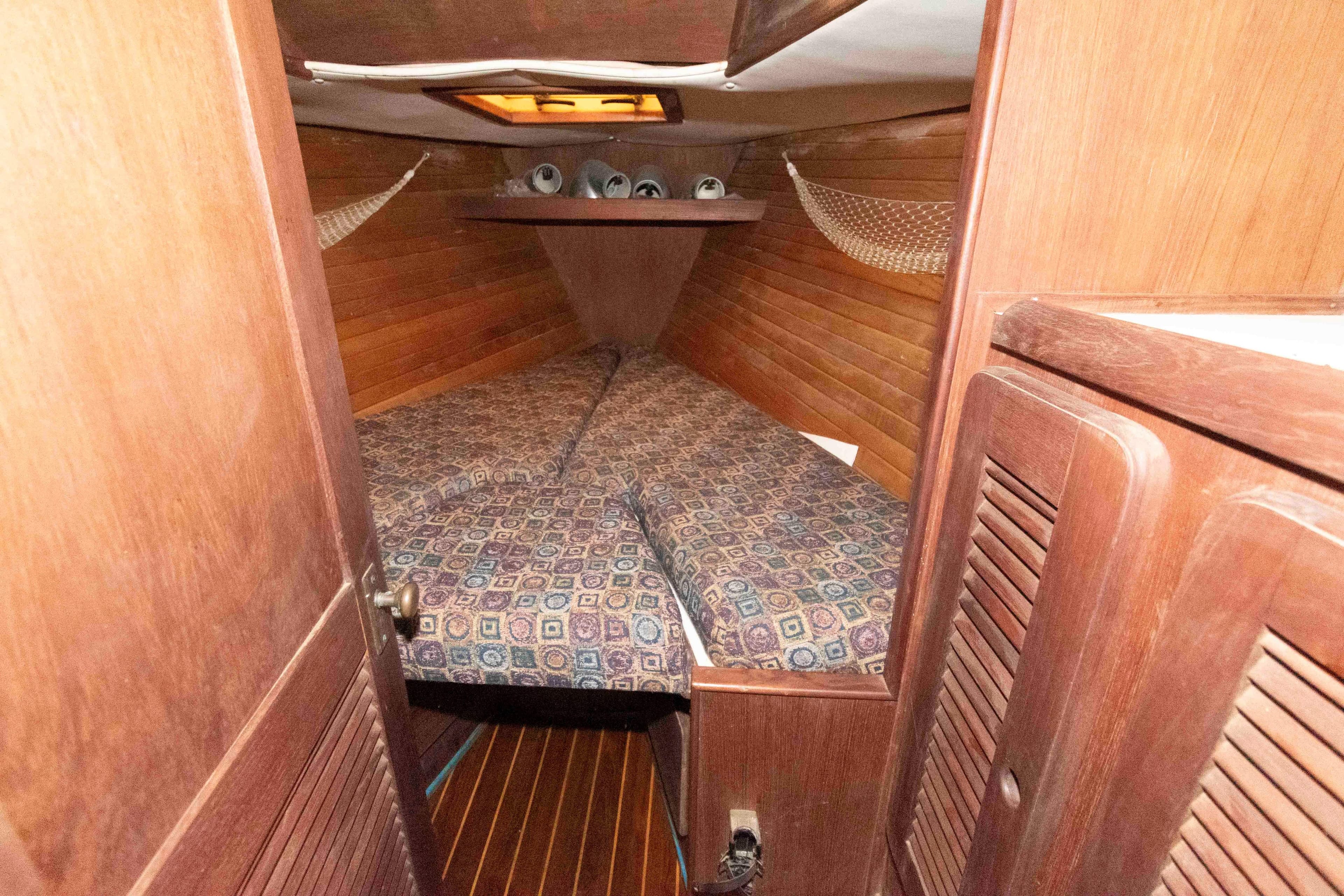 1985 Morgan 384 sailboat cabin with wooden interior and patterned bedding.