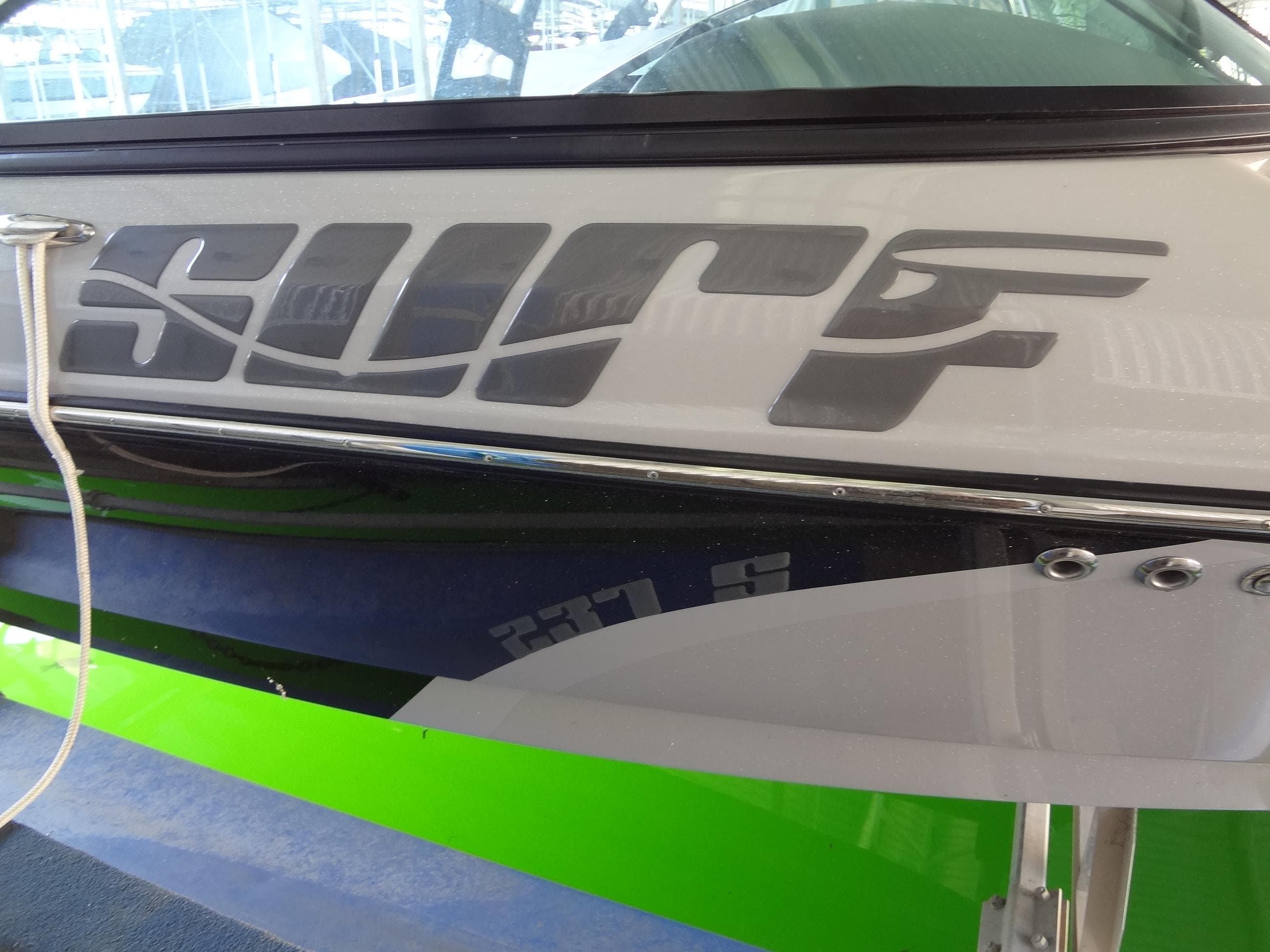 2022 Sanger V237 S boat with "Surf" decal and vibrant green accents.
