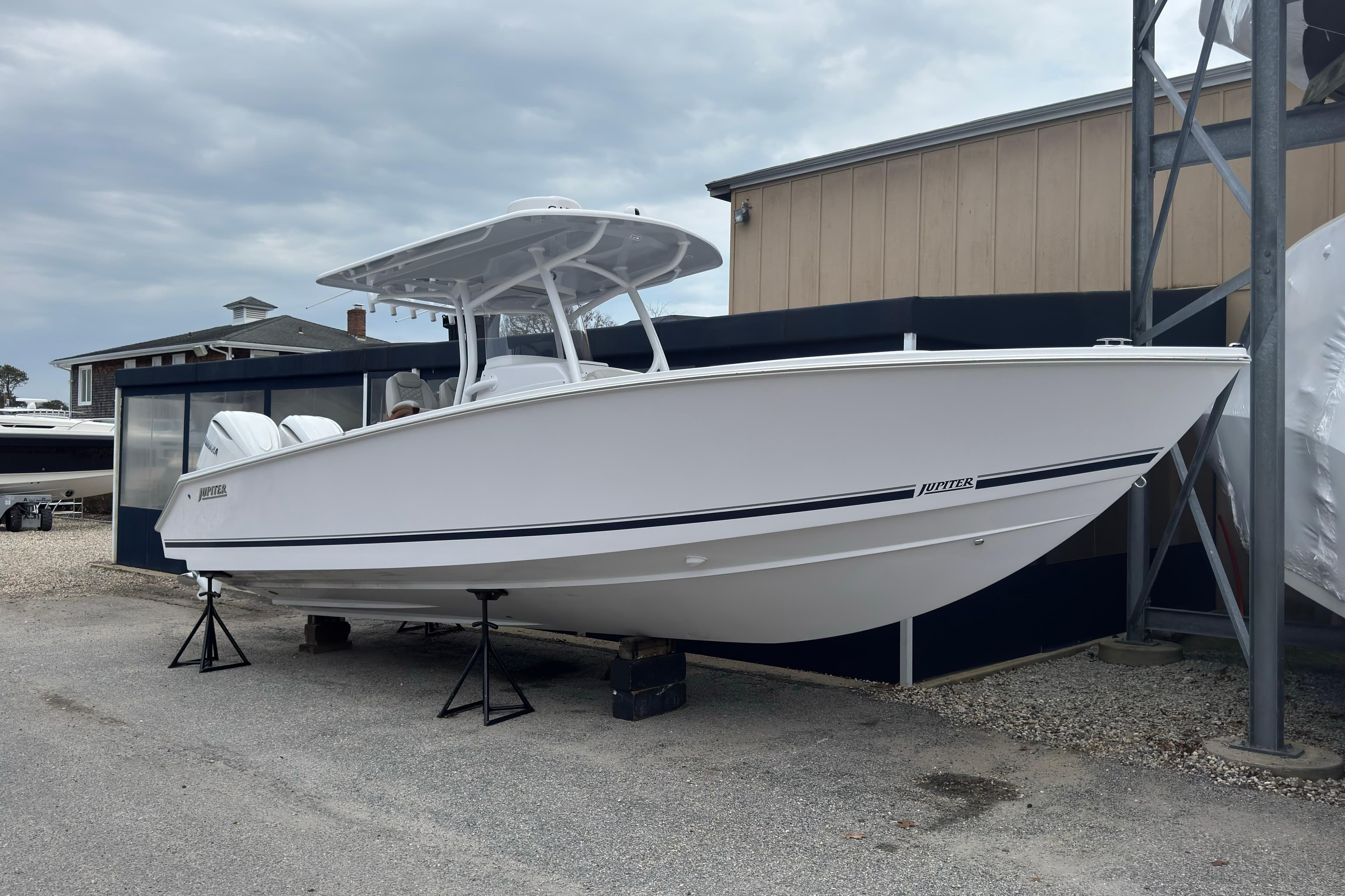 2026 Jupiter 30 boat on display, white hull, outdoor setting, overcast sky.