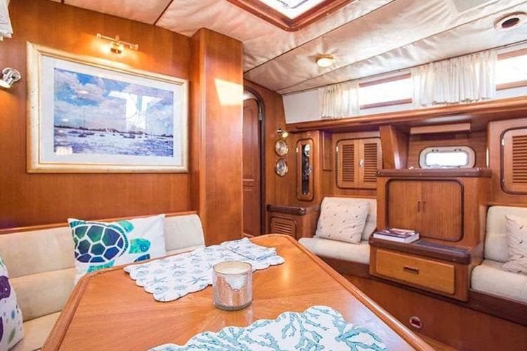 Luxurious interior of a 1999 Passport 456 yacht with elegant wood finishes and cozy seating.
