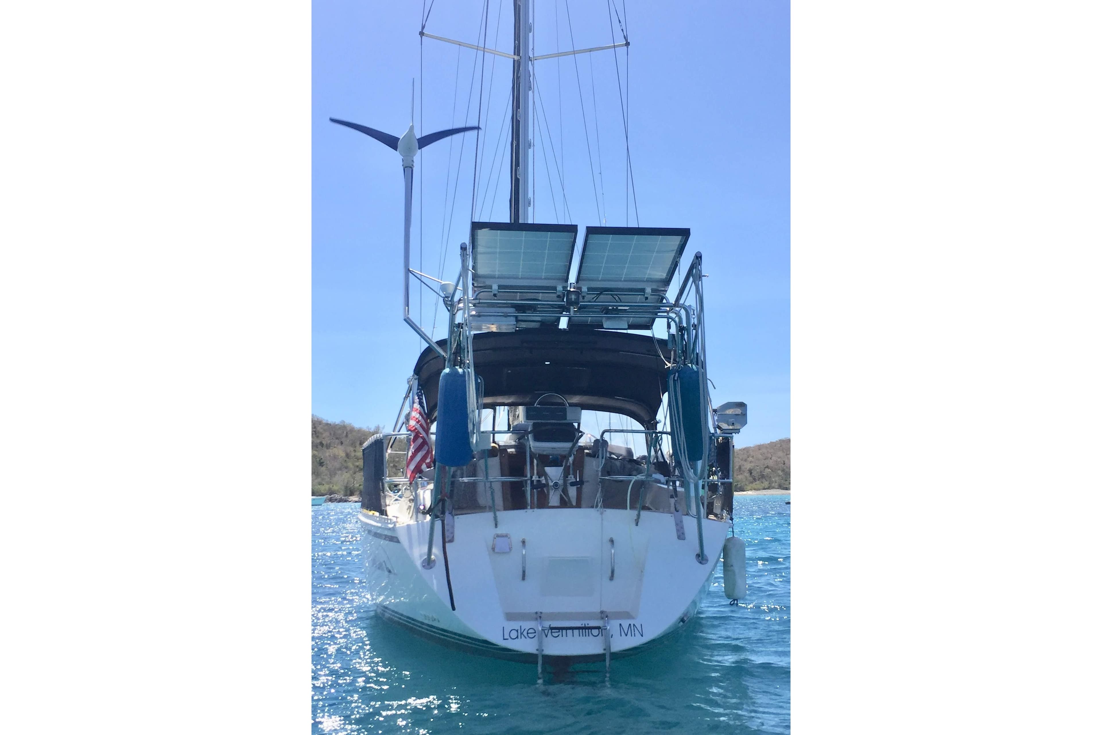 Sailboat Caliber 40LRC SE 2005 with solar panels and wind turbine on water.