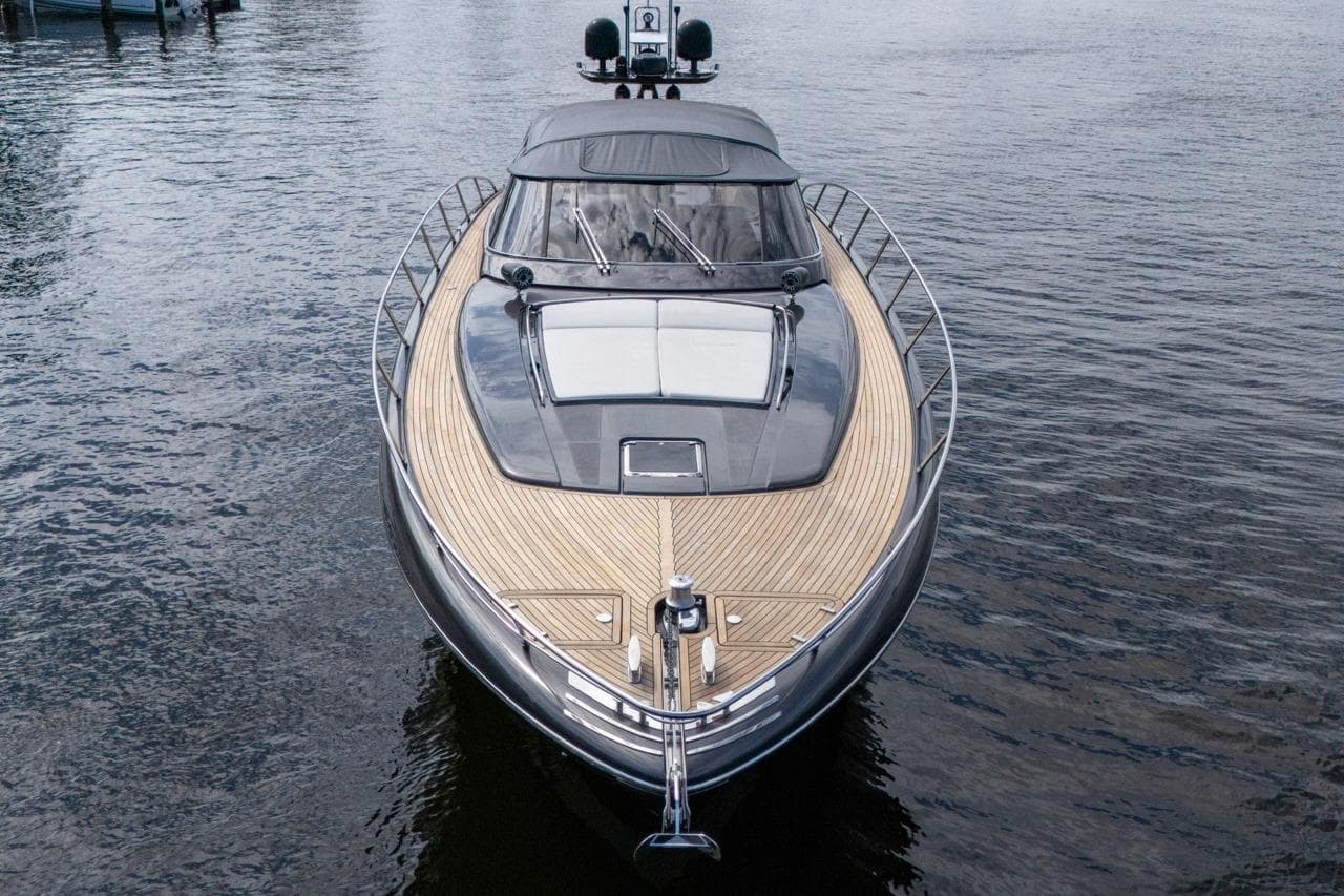 Luxury 2015 Riva 63 yacht on calm water, showcasing sleek design and wooden deck.