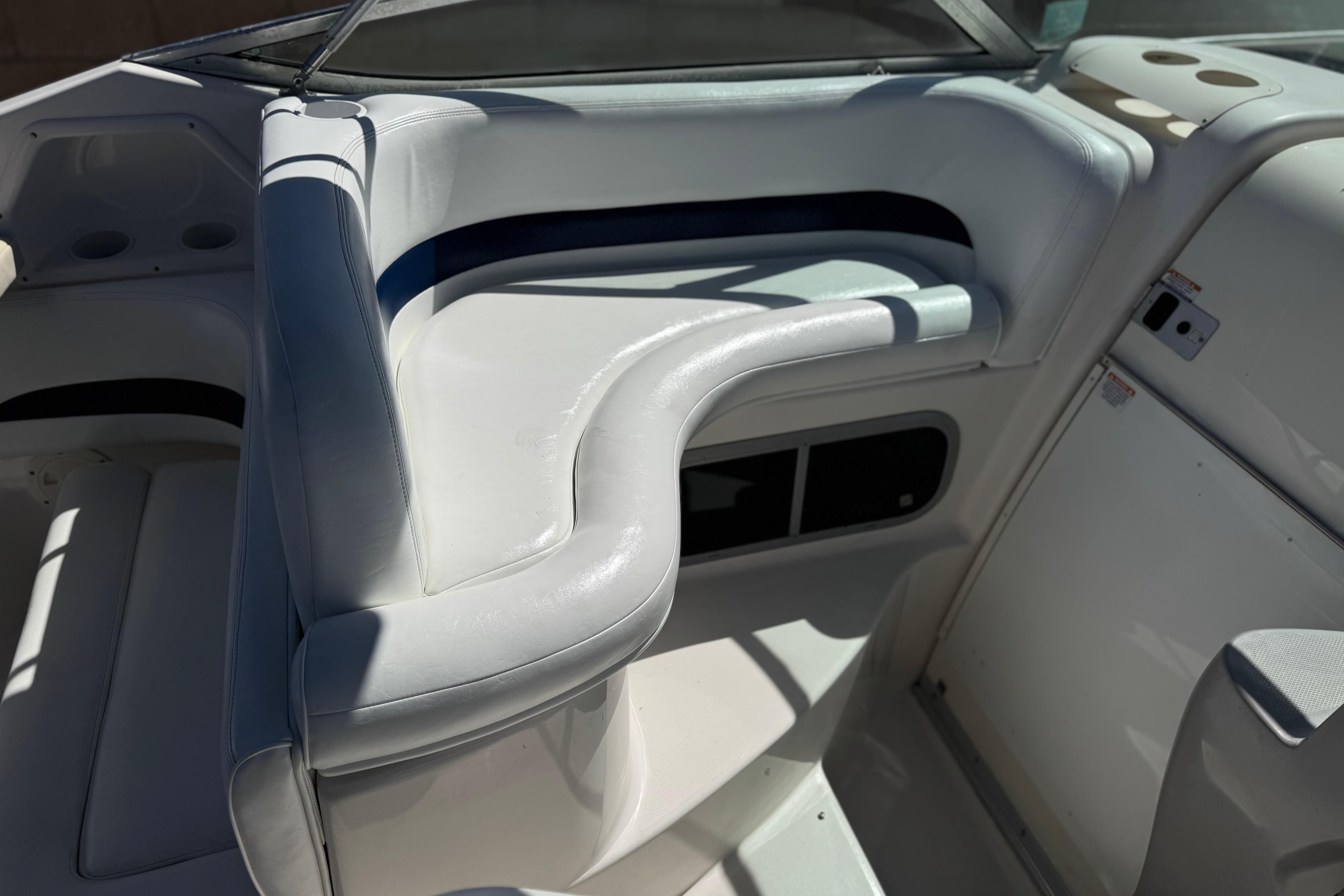 2004 Chaparral Signature 260 boat interior with white seating and storage compartments.