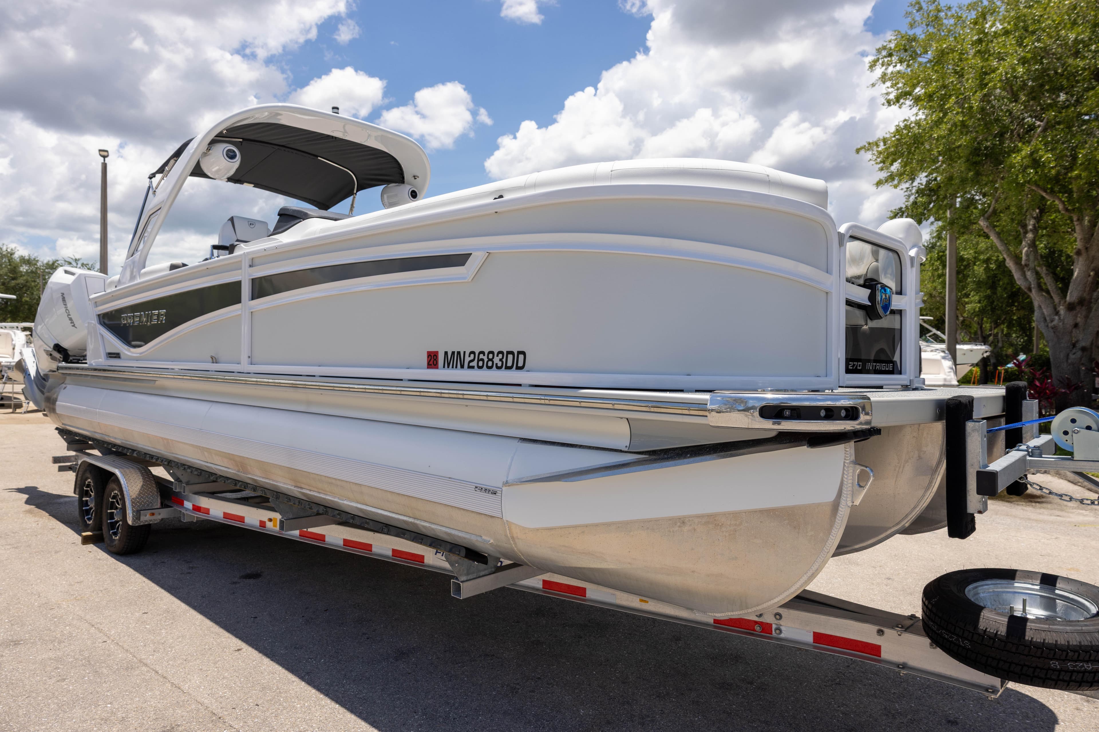 2026 Premier 270 Intrigue RF - CL pontoon boat on trailer under cloudy sky.