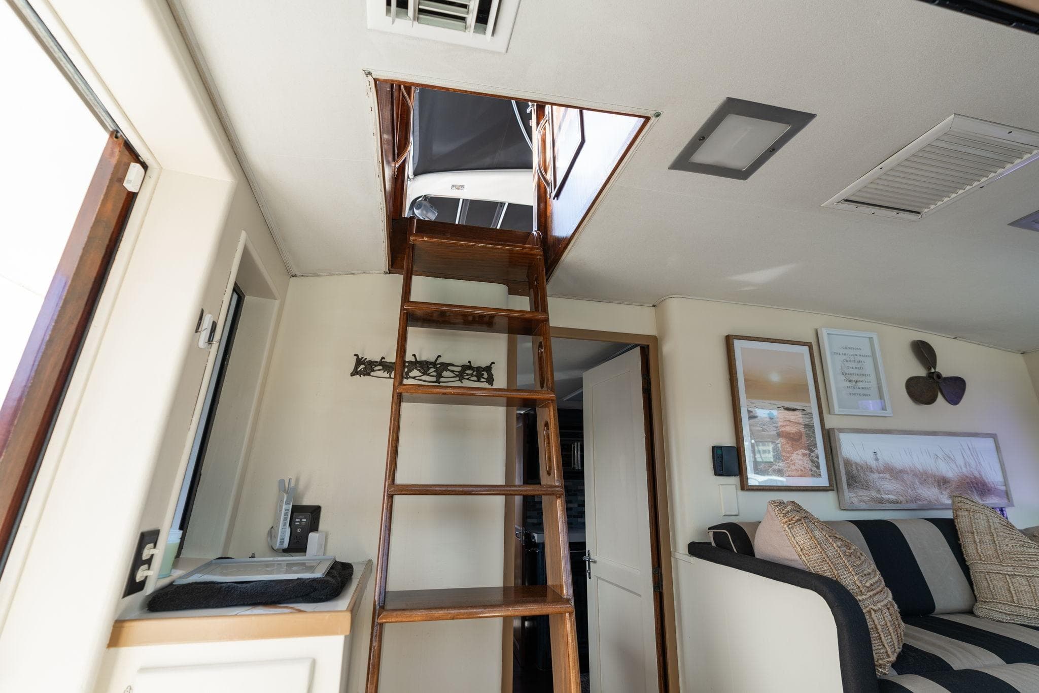 Interior of 1986 Hatteras 63 Motor Yacht with wooden ladder and cozy seating area.