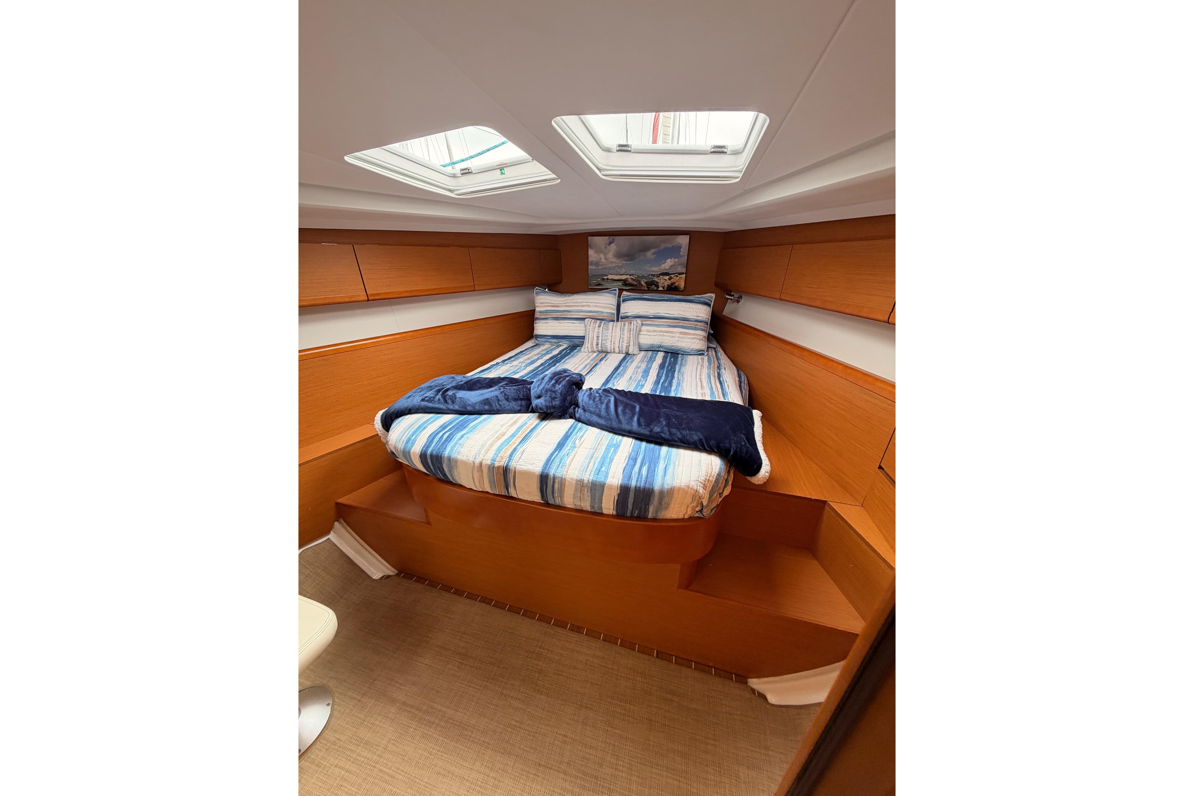 Cozy cabin interior of 2014 Jeanneau Sun Odyssey 50 DS with striped bedding.