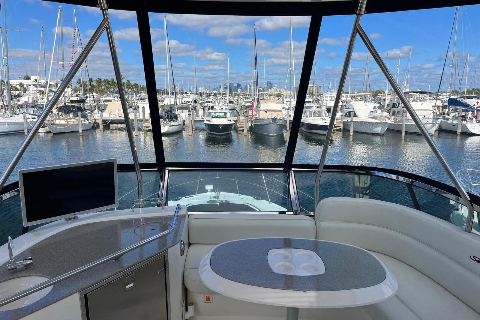 2006 Sea Ray 52 Sedan Bridge yacht interior with marina view, featuring seating and a table.