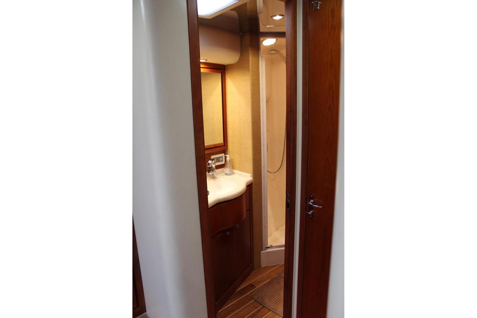 Luxurious bathroom interior of 2009 Bertram 510 yacht with wooden accents and modern fixtures.