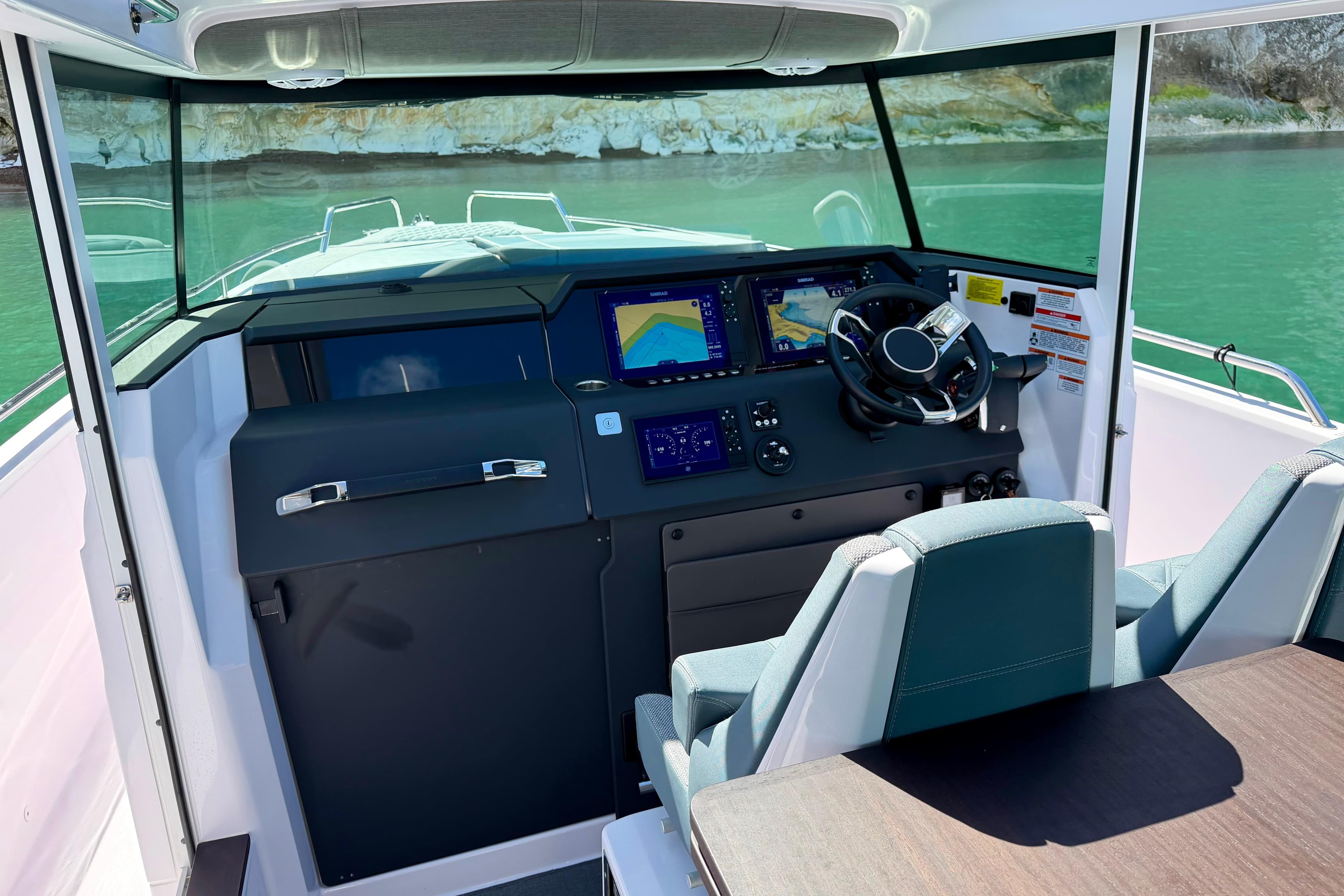 2024 Axopar 37 XC Cross Cabin helm with dual screens and steering wheel.