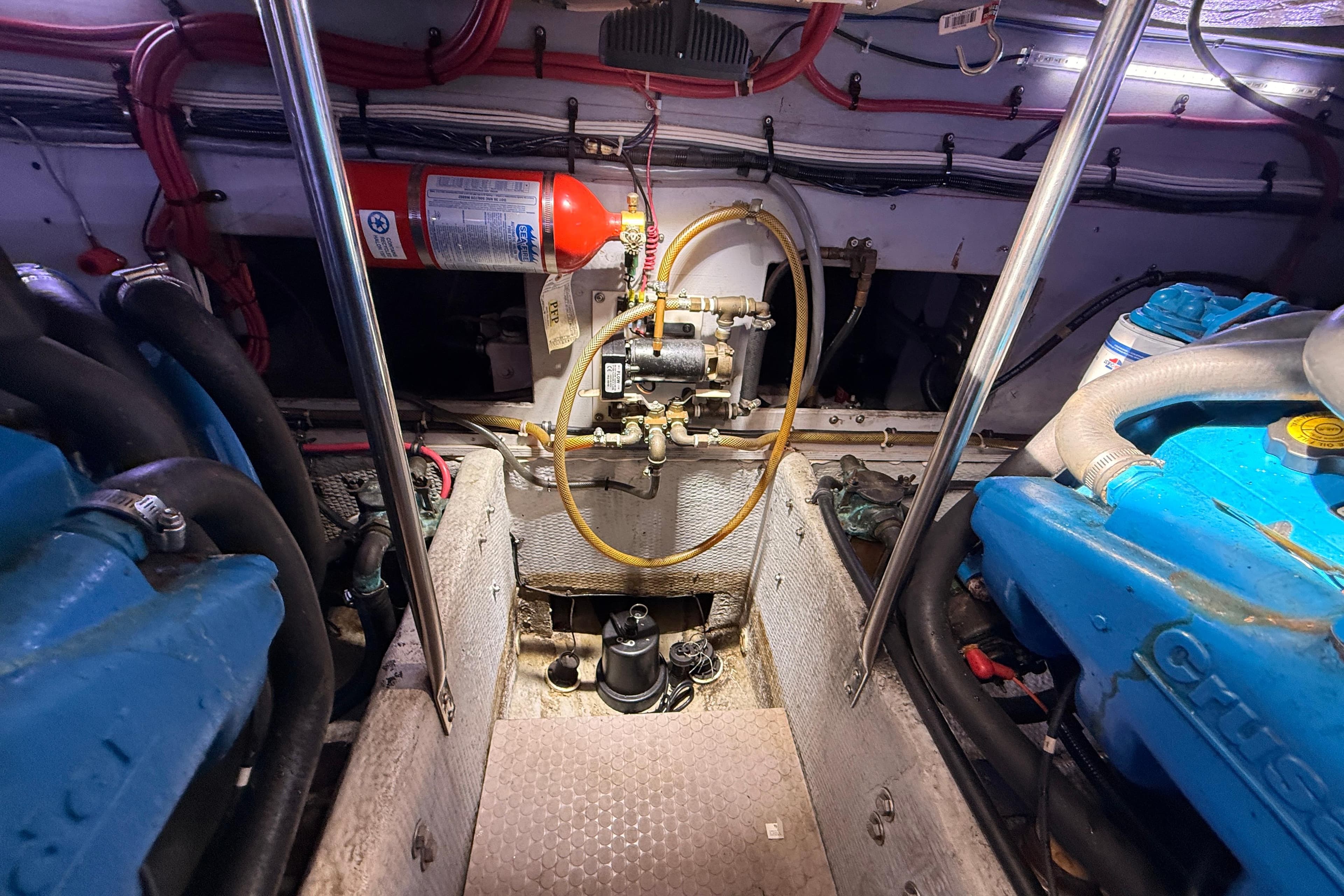 Engine room of a 1998 Silverton 40 Convertible boat with visible components and fire extinguisher.