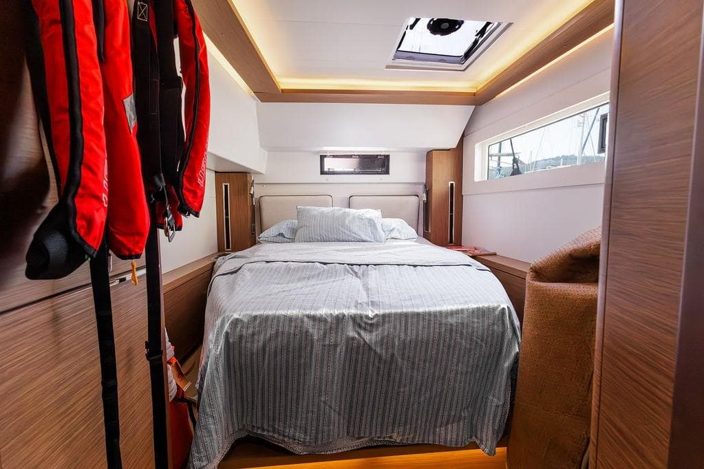 Luxurious cabin interior of 2021 Lagoon 46 yacht with cozy bed and modern design.