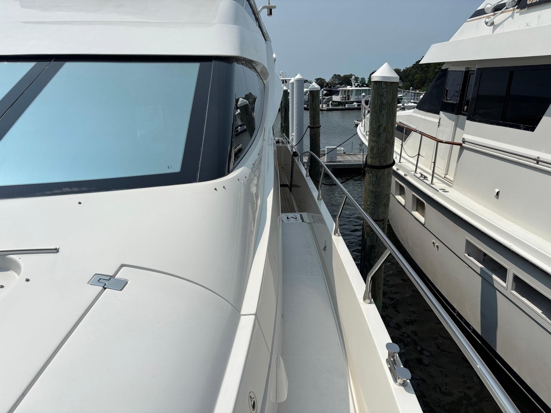 Luxury Marquis 65 yacht docked at marina, 2006 model, sleek design, white exterior.