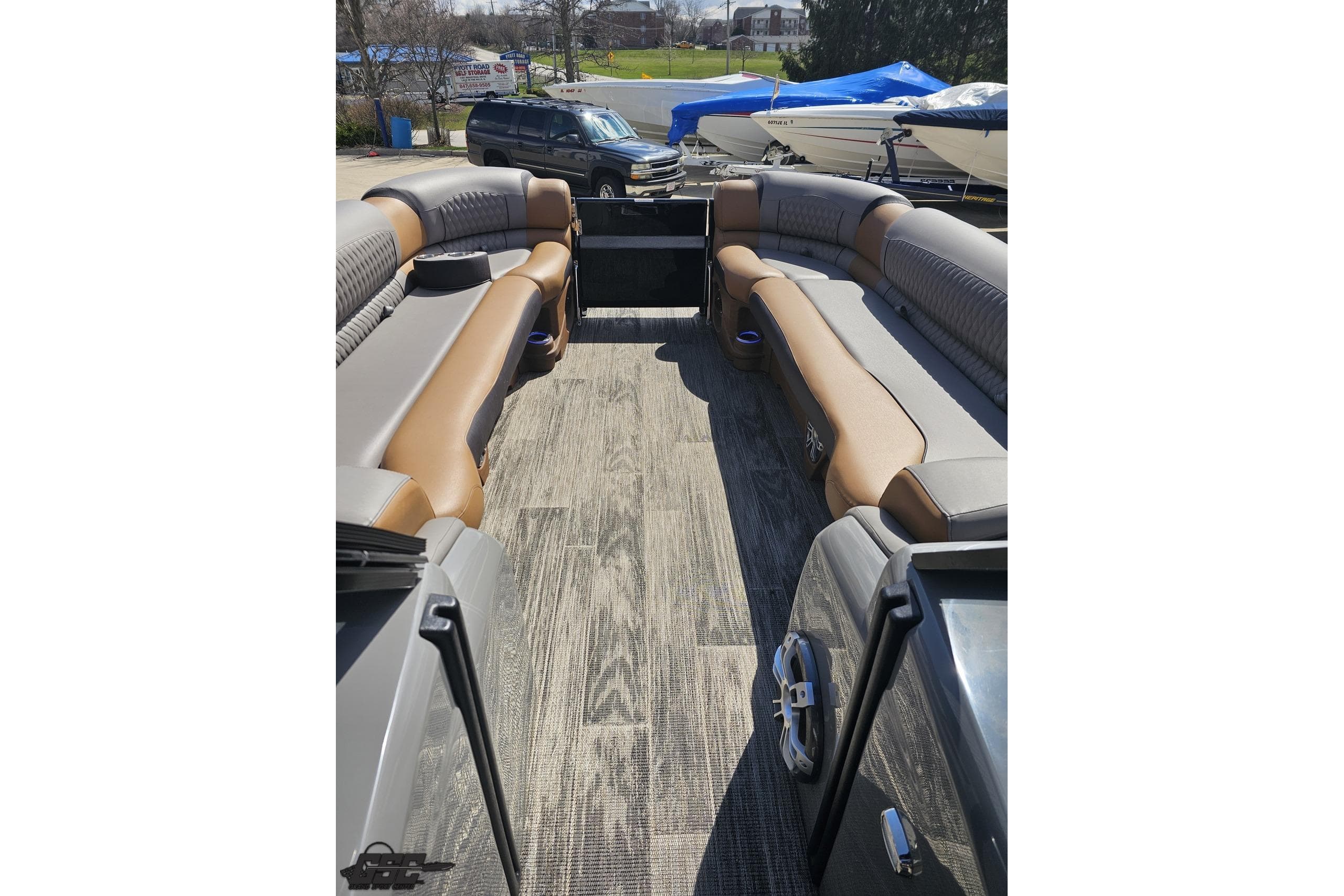 2024 Avalon Excalibur Quad Lounge Windshield boat interior with luxurious seating and wood-style flooring.