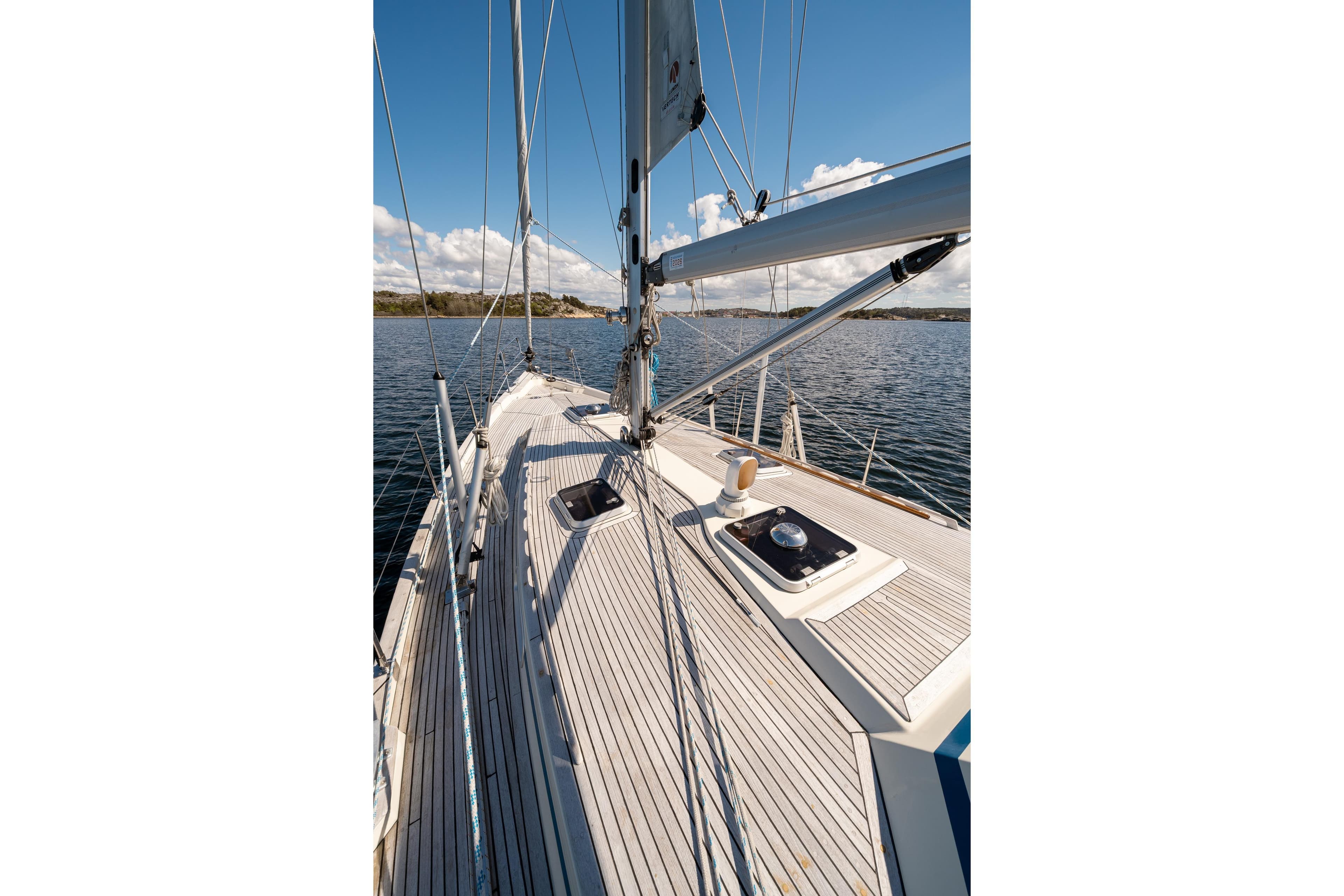 Sailboat deck view on a 1997 Malo 42, sailing on calm waters under a clear sky.