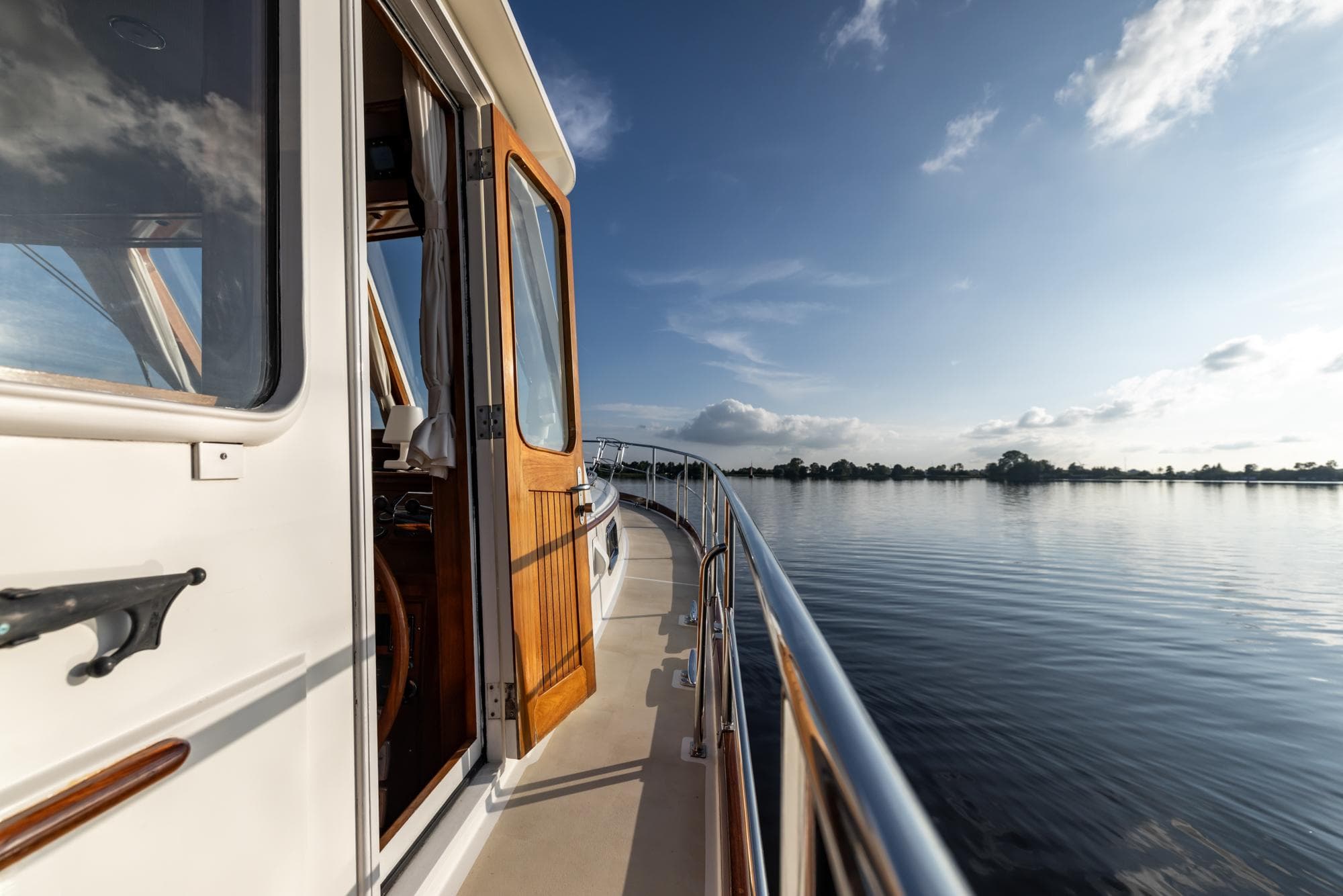 1999 Grand Banks 43 Eastbay FB yacht cruising on calm waters under a clear sky.
