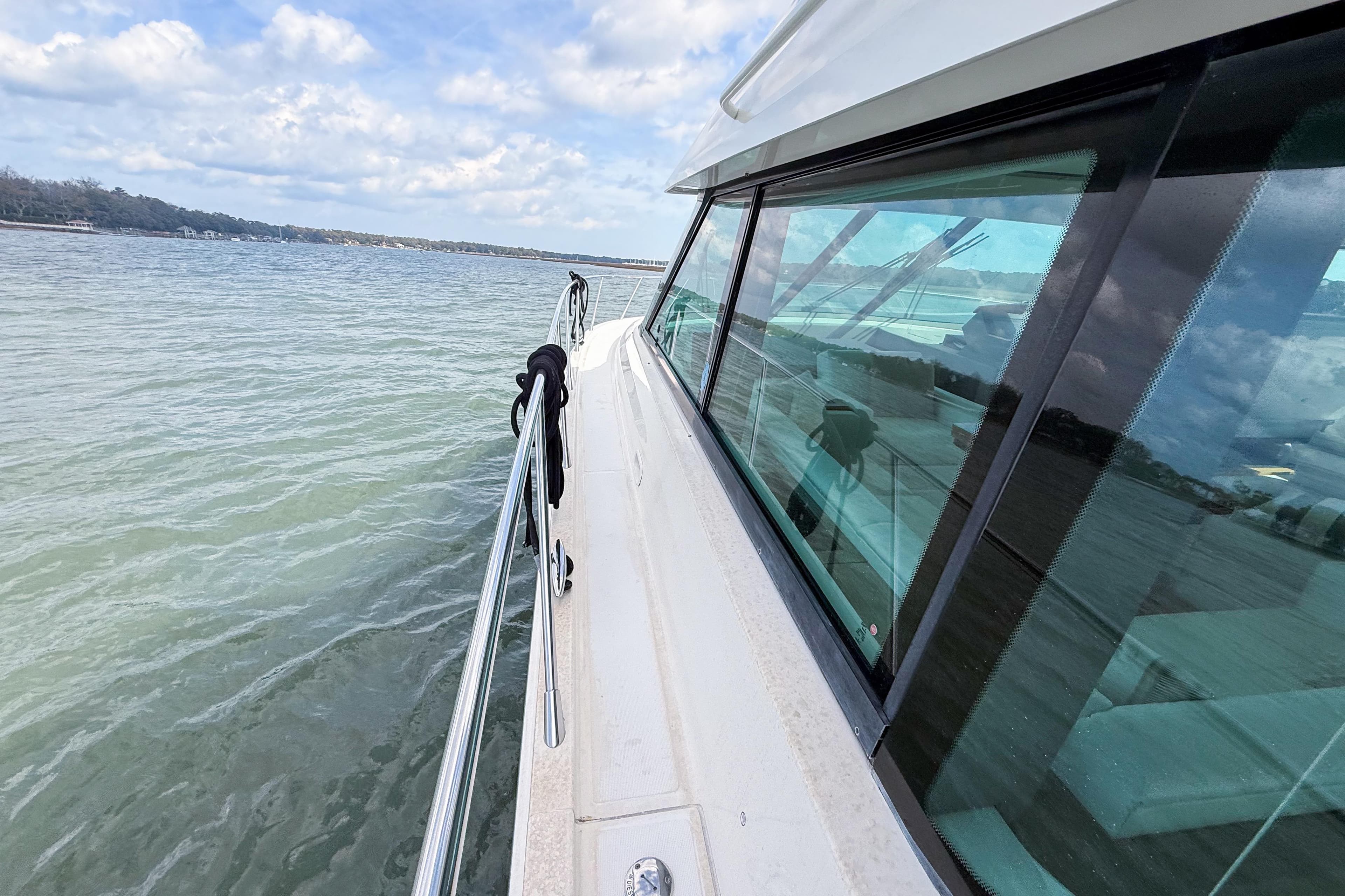 2019 Tiara Yachts F53 Flybridge cruising on calm waters under a cloudy sky.