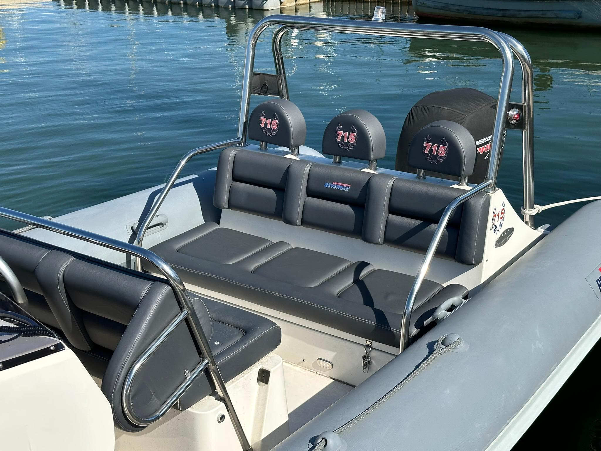 2004 Revenger 715 boat with sleek seating, docked on calm water.