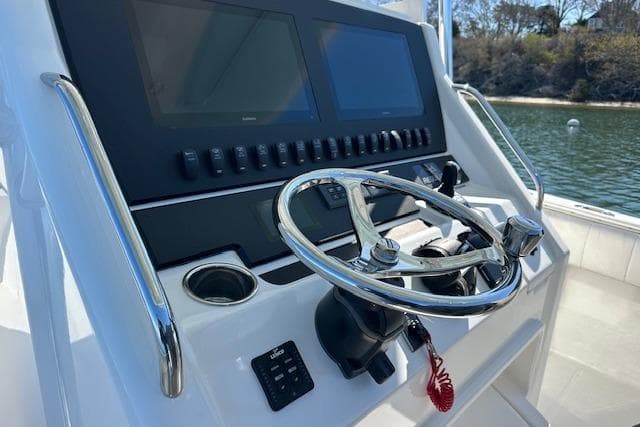 2015 Regulator 34 boat helm with dual screens and stainless steel steering wheel.