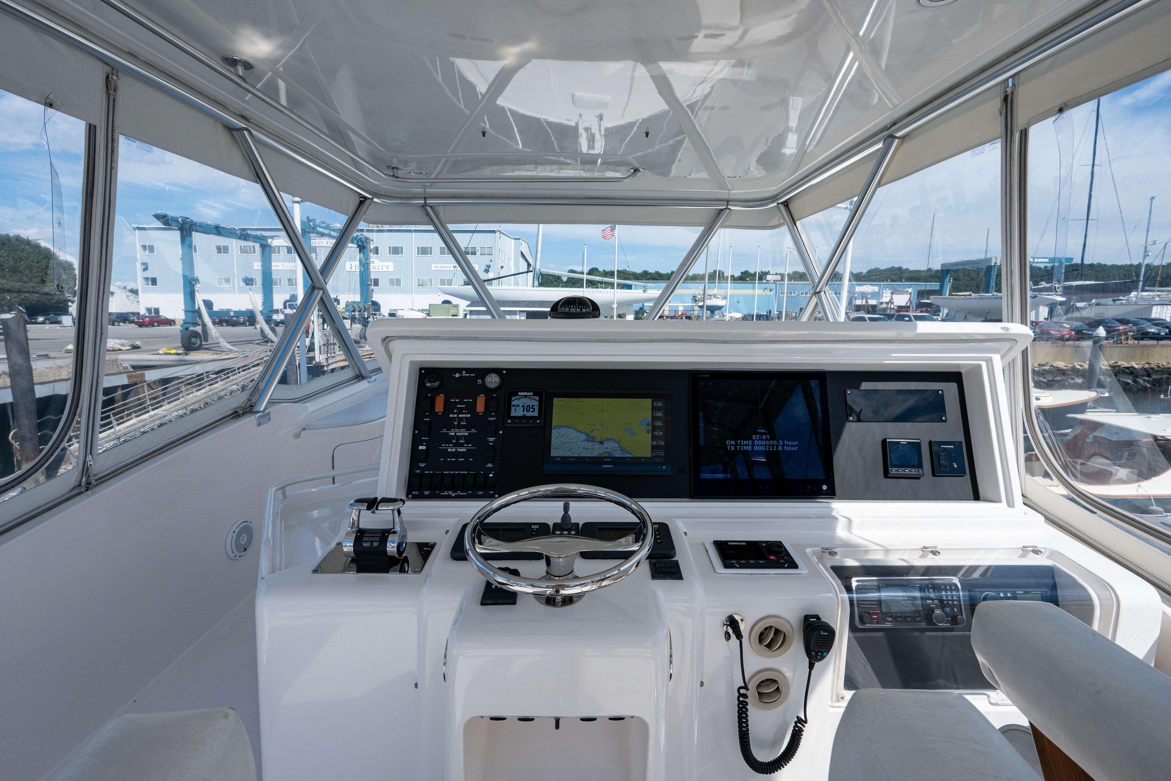 2008 Bertram 570 yacht helm with advanced navigation systems and panoramic marina view.