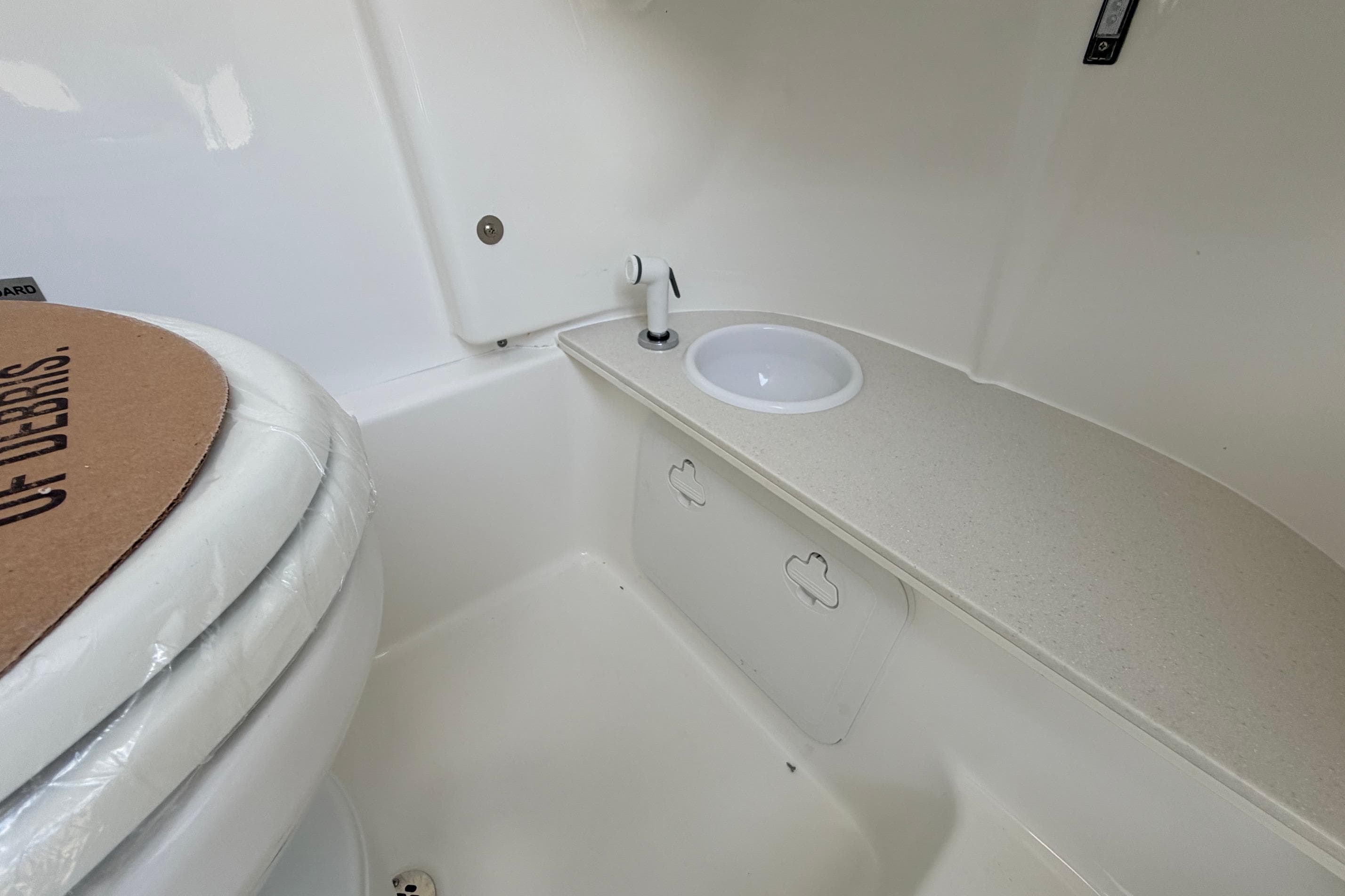 2026 Sea Pro 262 Offshore boat bathroom with sink and toilet.