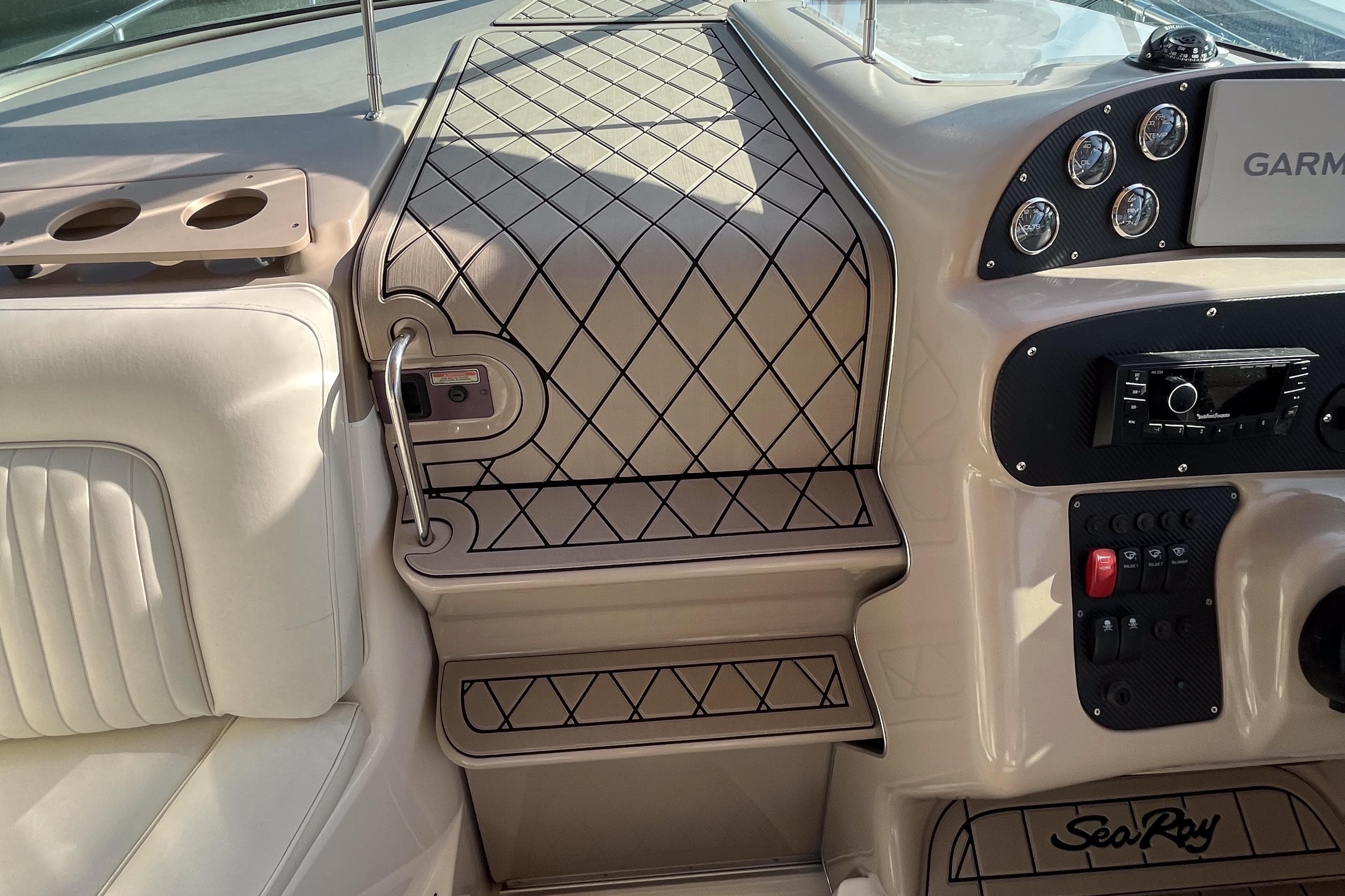 2001 Sea Ray 270 Sundancer cockpit with beige upholstery and control panel.