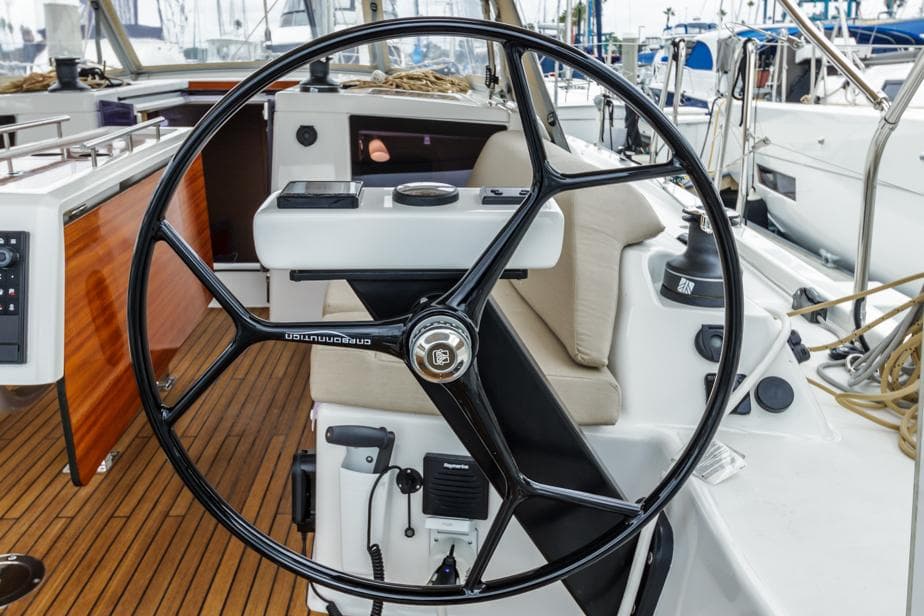Dufour 390 yacht steering wheel, 2023 model, with teak deck and modern cockpit design.