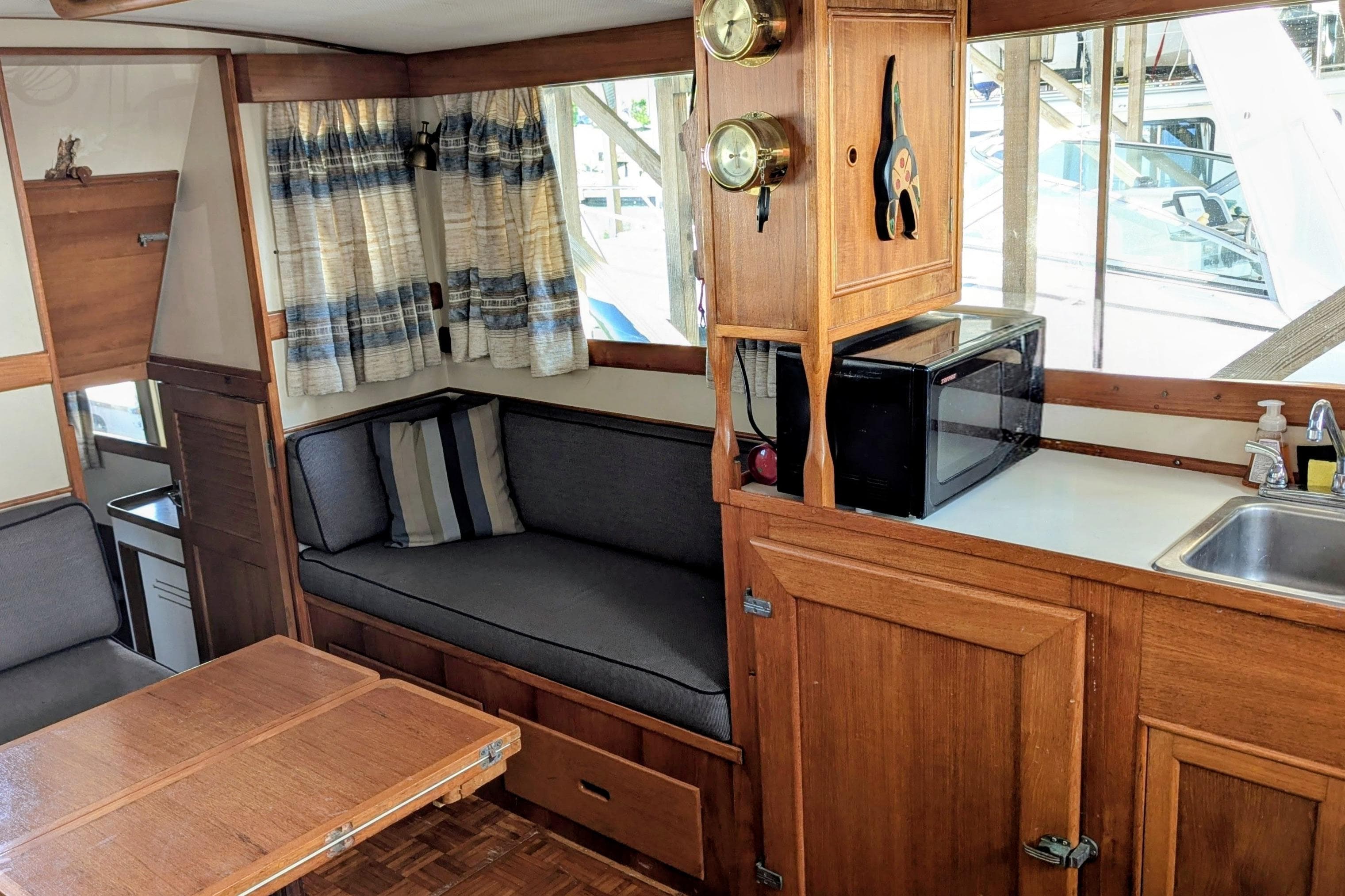 Interior of a 1974 Grand Banks 36 Classic boat with wood cabinetry and seating area.