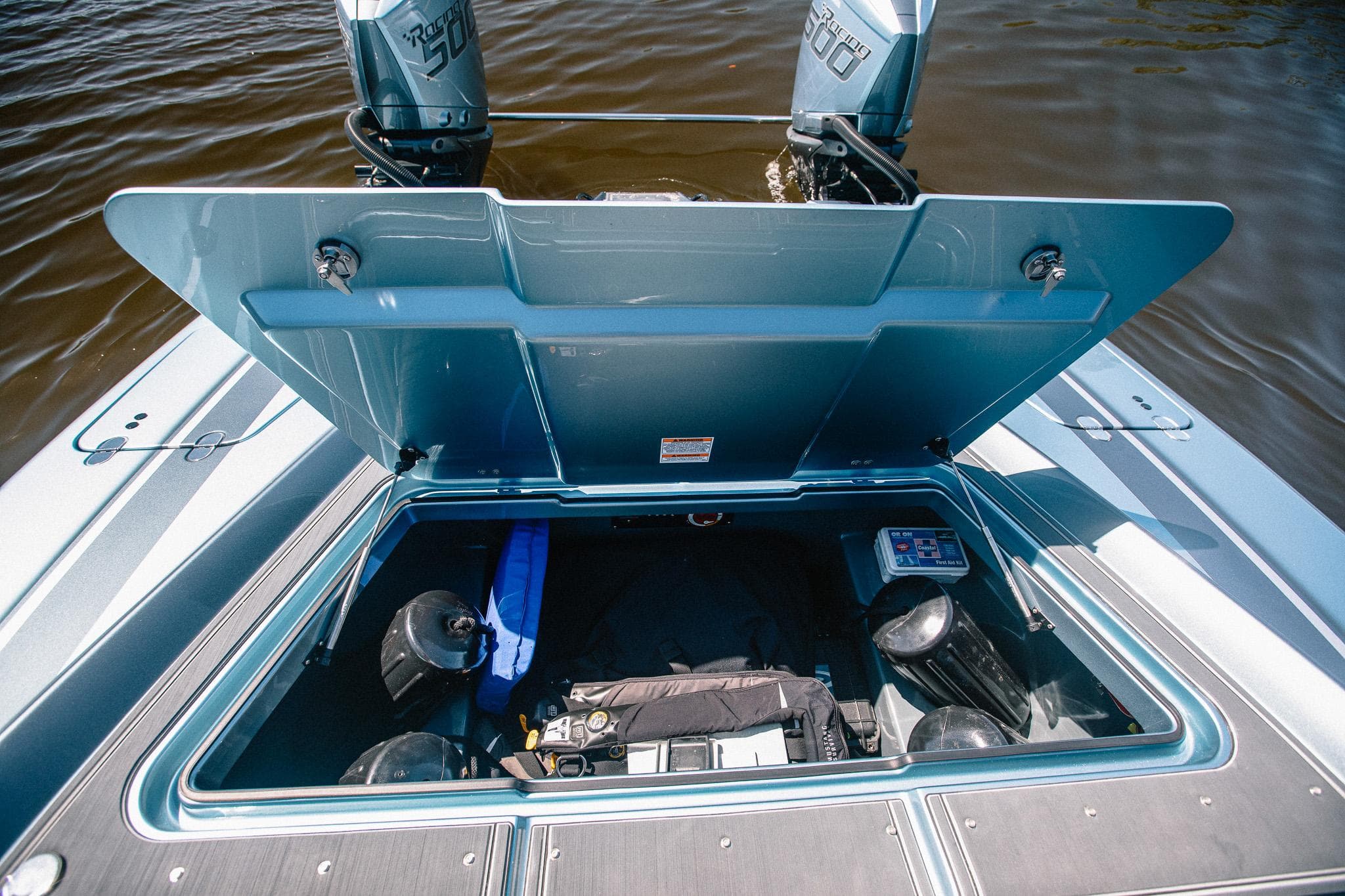 Open storage compartment on 2024 MTI 390X boat with visible equipment.