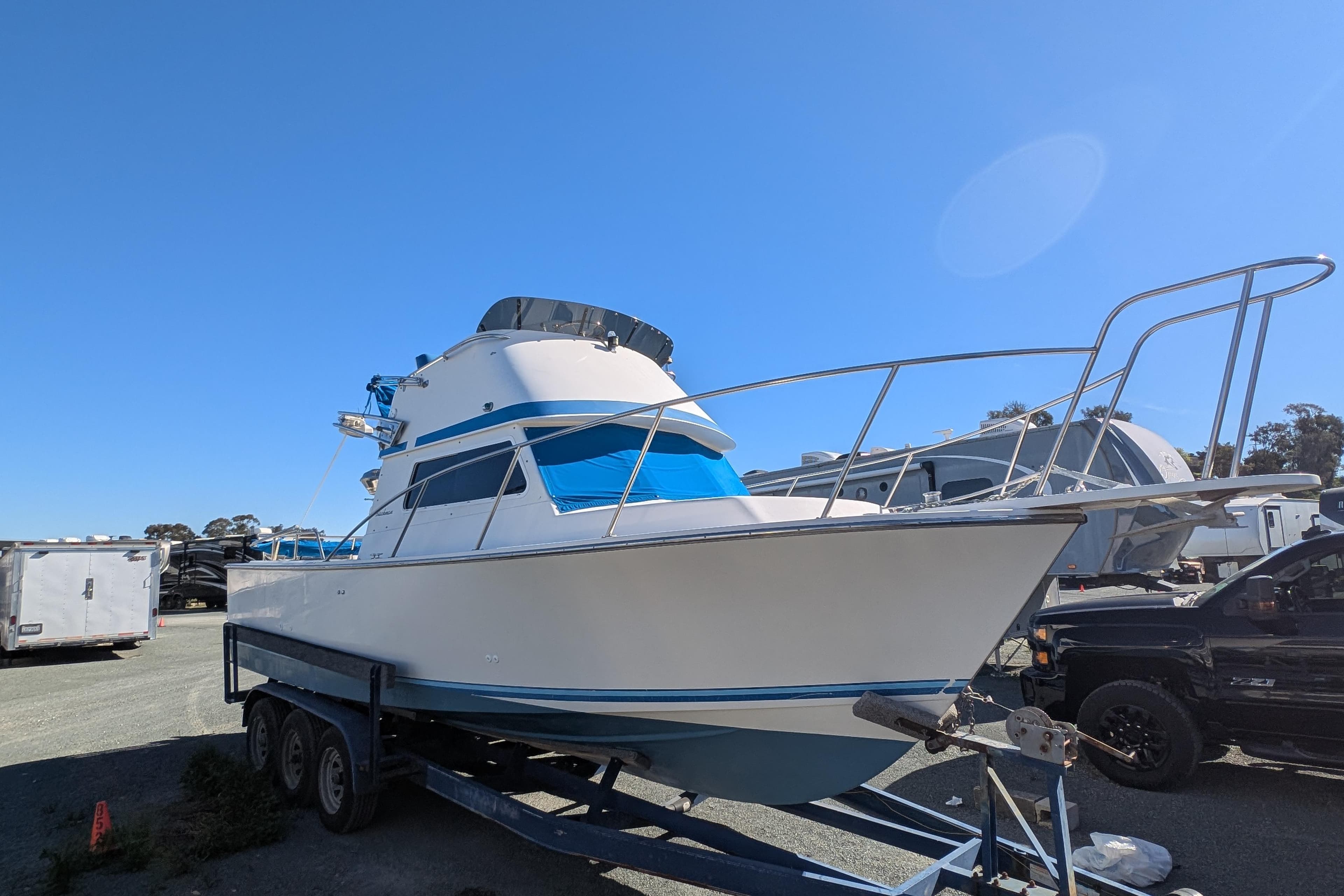 1989 Blackman Billfisher 26 boat on trailer under clear blue sky.