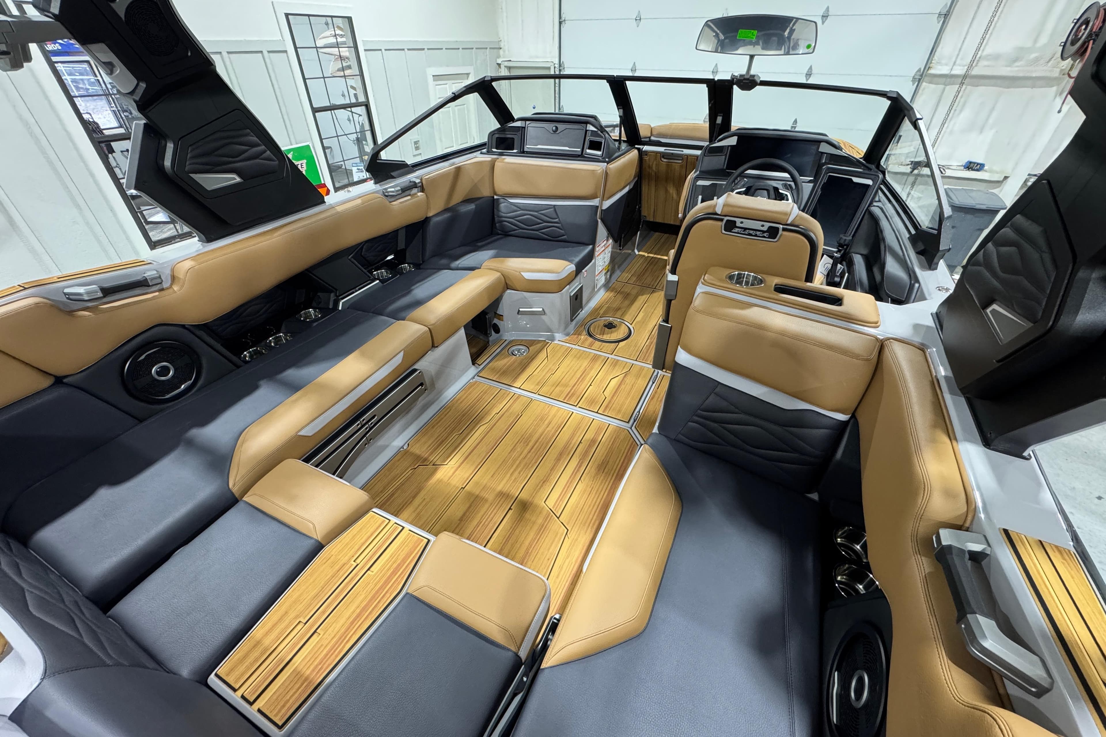 2026 Supra SA boat interior with luxurious seating and wood flooring.