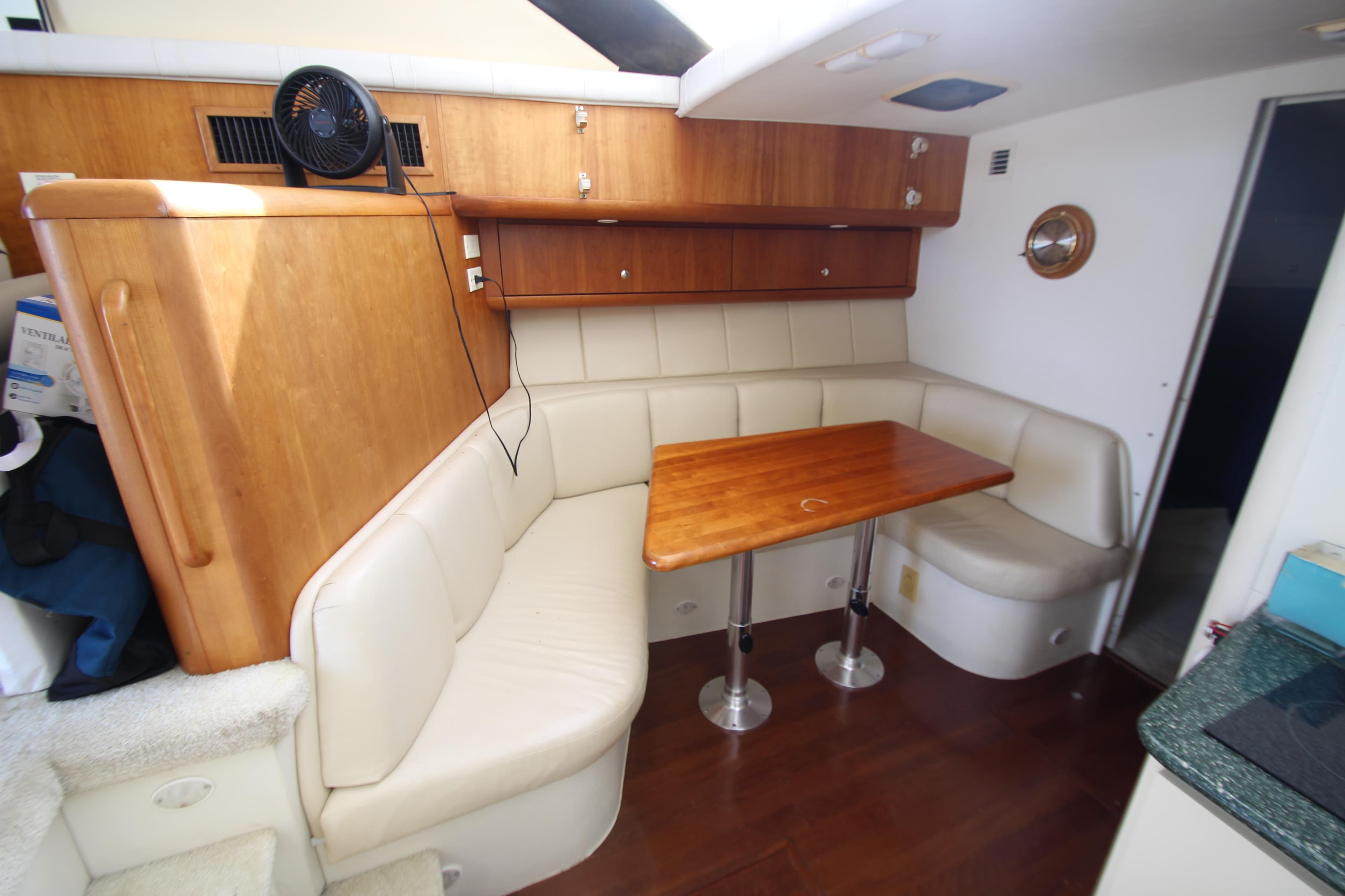 Interior of 2000 Silverton 37 Convertible yacht with cozy dining area and wooden table.