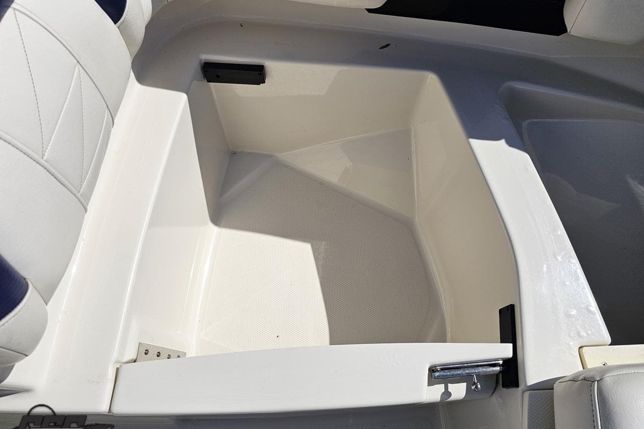 Storage compartment in a 2013 Monterey M3 Sport Boat, featuring white and blue seating.