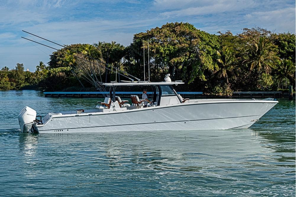 2023 Freeman 47 boat cruising on a serene waterway with lush greenery.