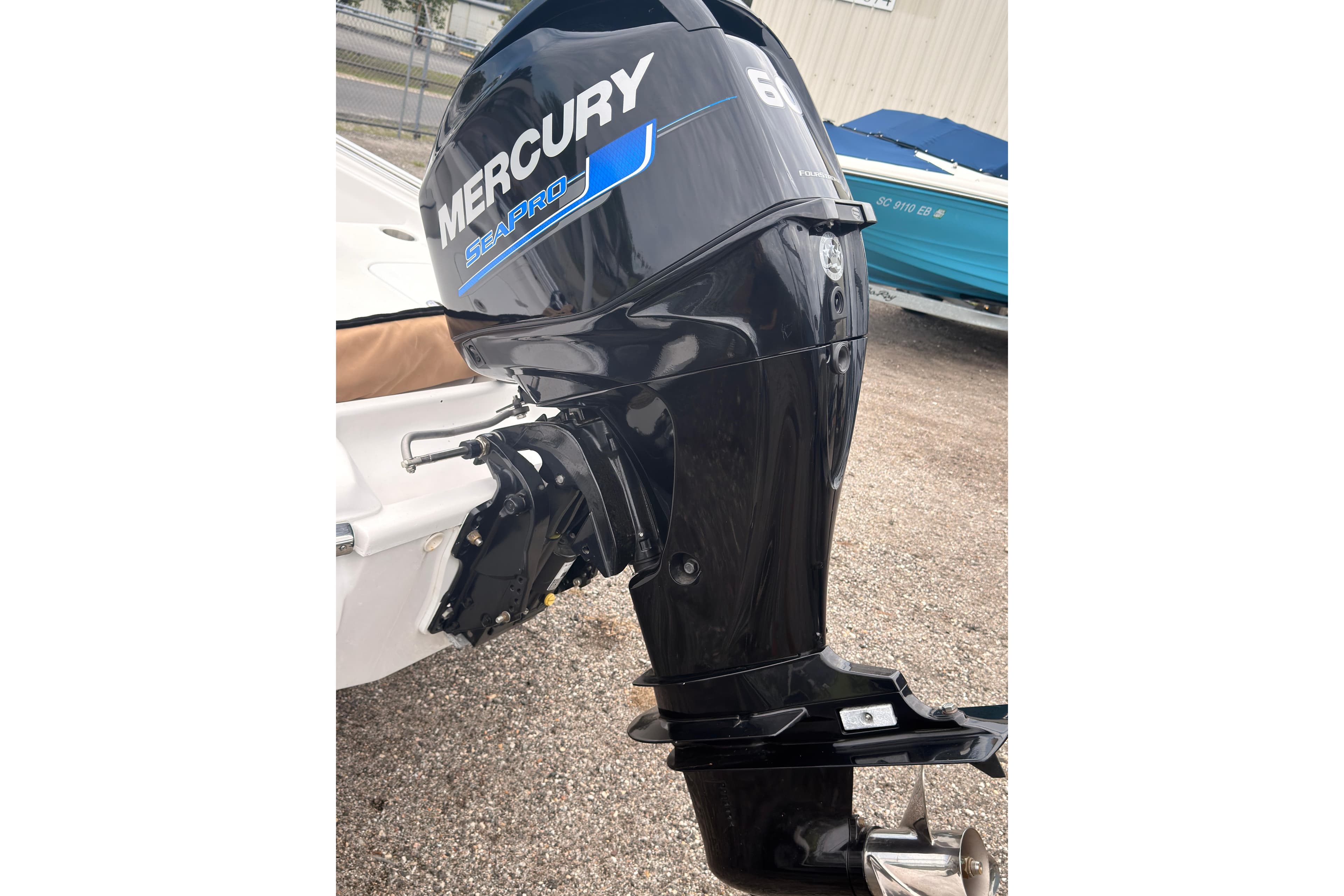 Outboard motor on a boat, featuring Mercury SeaPro branding, parked on gravel.