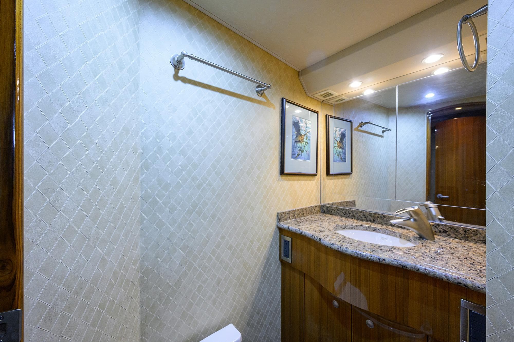 Luxurious bathroom in 2007 Viking 56 Convertible yacht with granite countertop and elegant decor.