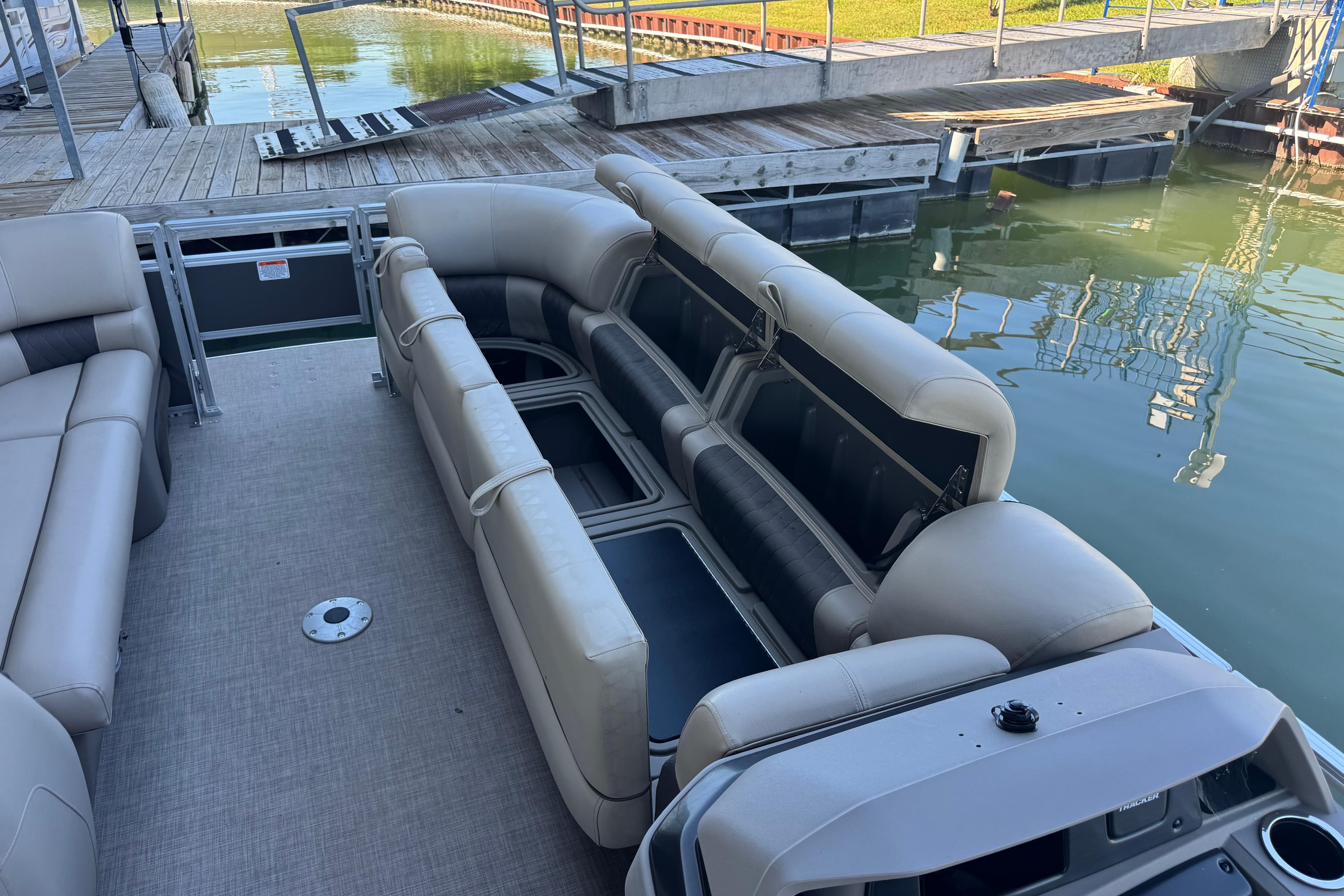 2024 Sun Tracker Party Barge 24 DLX pontoon boat with spacious seating at a dock.