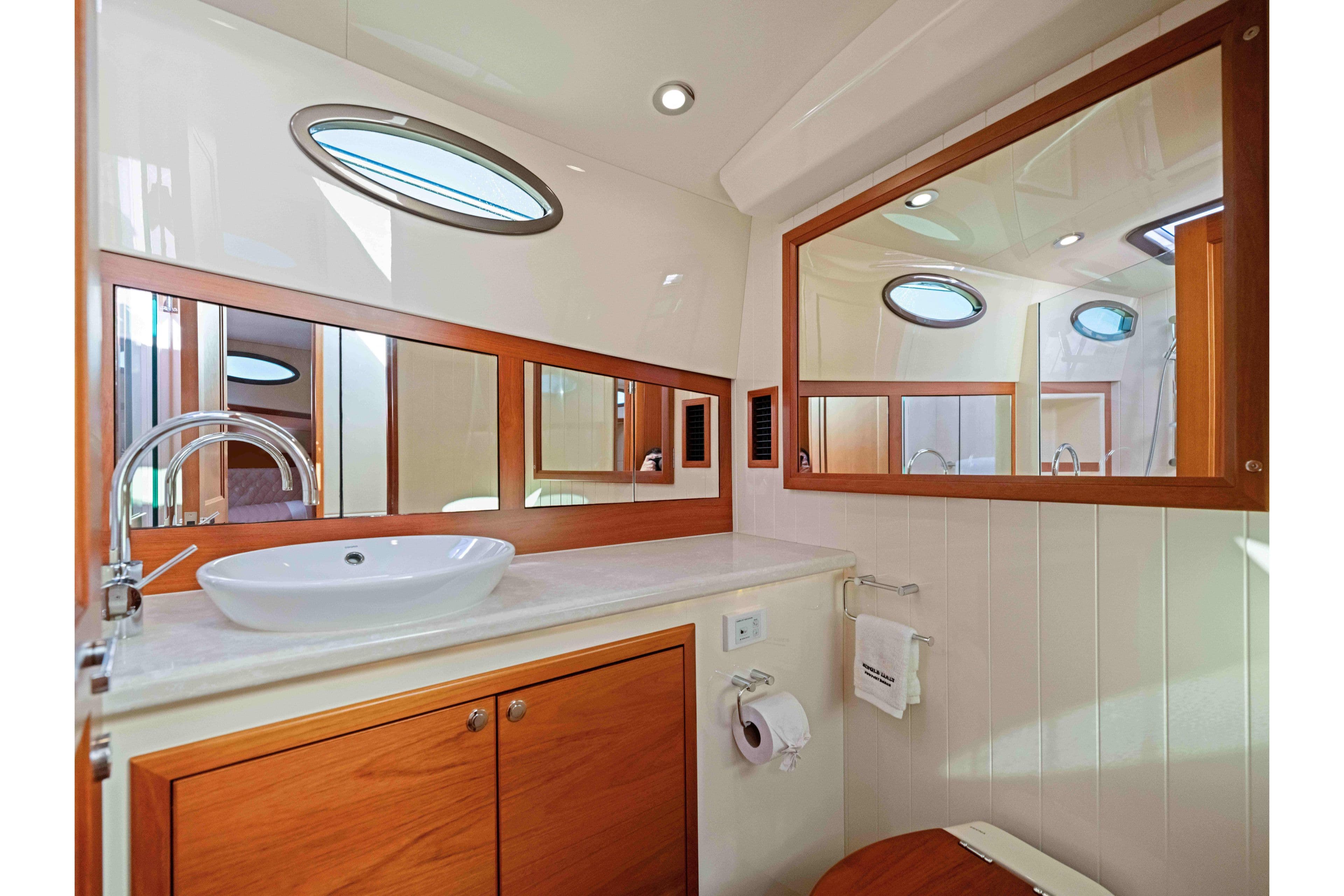Luxurious bathroom interior of 2015 Palm Beach Motor Yachts PB45 with elegant wood accents.