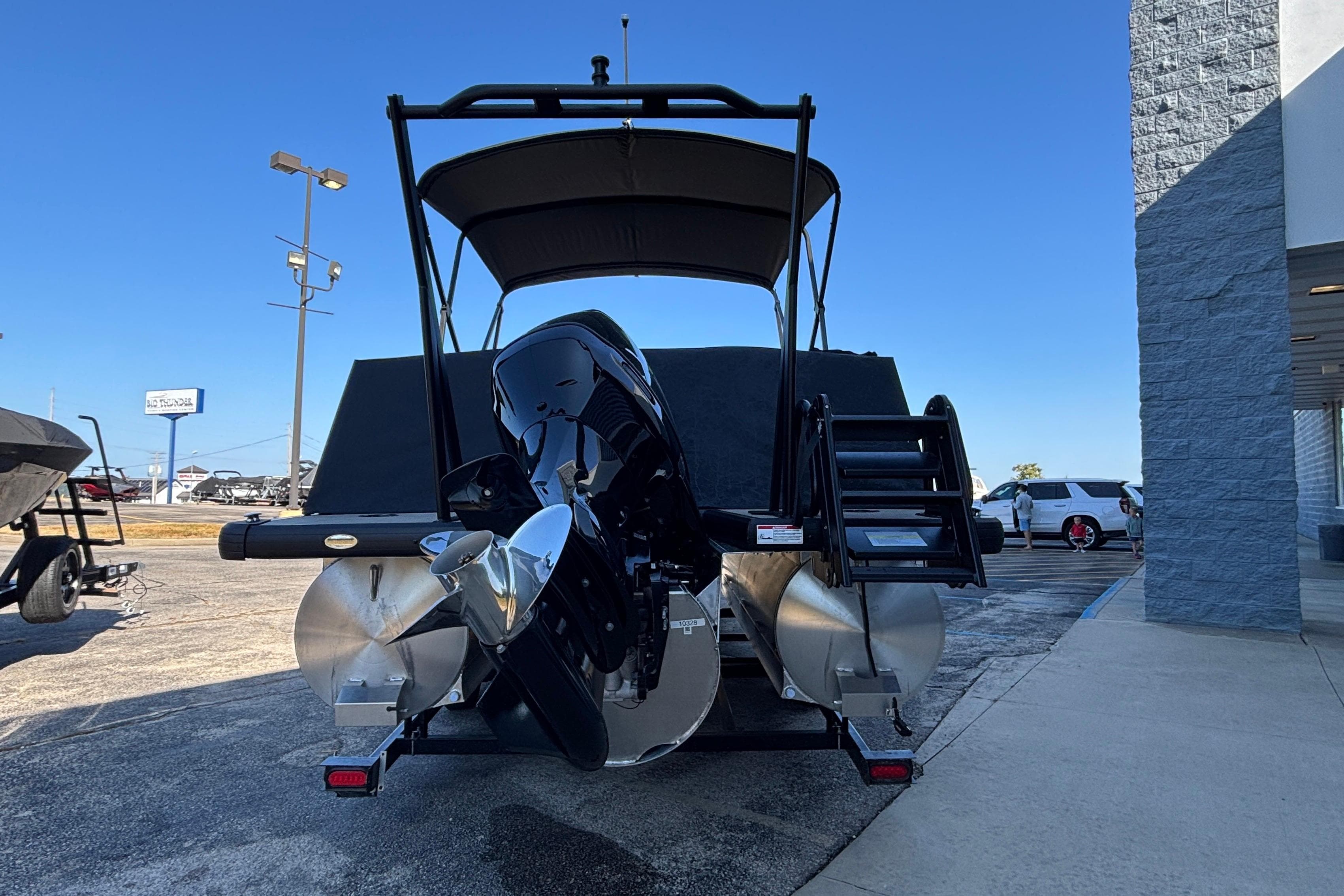 2026 Viaggio Z24U pontoon boat with powerful outboard motor, parked outdoors.