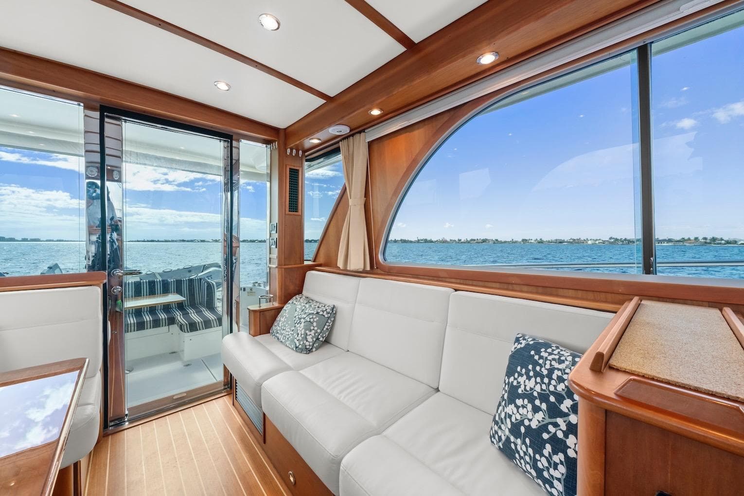 2019 Sabre 45 Salon Express interior with ocean view, featuring elegant wood and white seating.