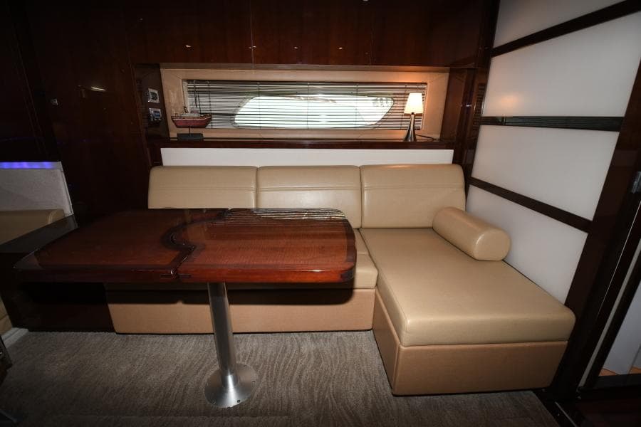 Interior of 2010 Sea Ray 450 Sundancer with beige leather seating and wooden table.